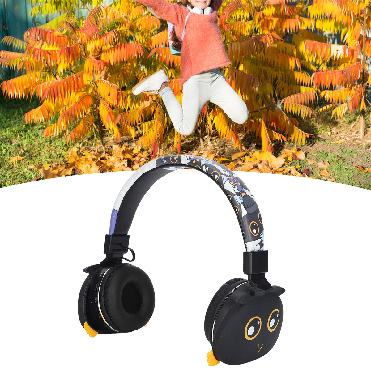 Ein Mädchen springt vor Freude über ein Paar Kopfhörer im Eulen-Design, vor einem Hintergrund aus Herbstlaub.