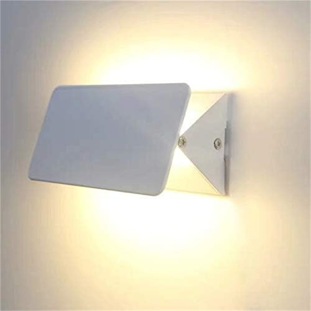 Weiße Wandleuchte mit rechteckigem Schirm. Die Lampe befindet sich an einer beigen Wand und leuchtet.