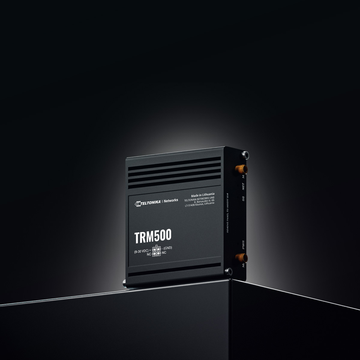 Zwart TRM500-apparaat op een zwart oppervlak tegen een donkere achtergrond.