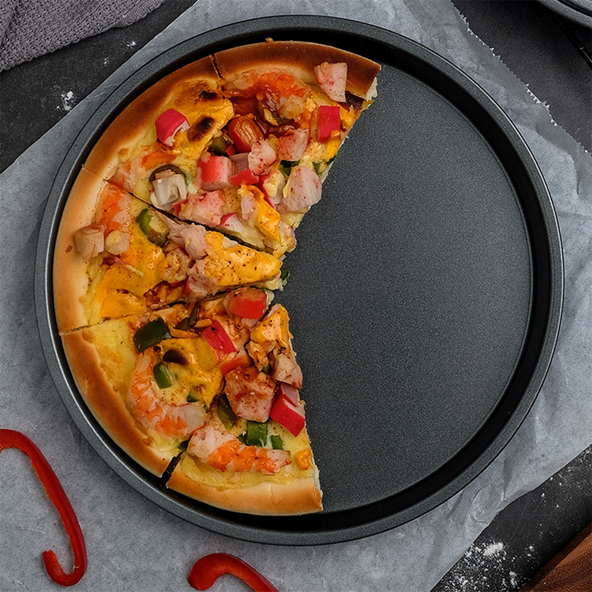 Pizza in einer Pfanne. Pizza mit Zutaten in Scheiben geschnitten auf einer schwarzen Pfanne.