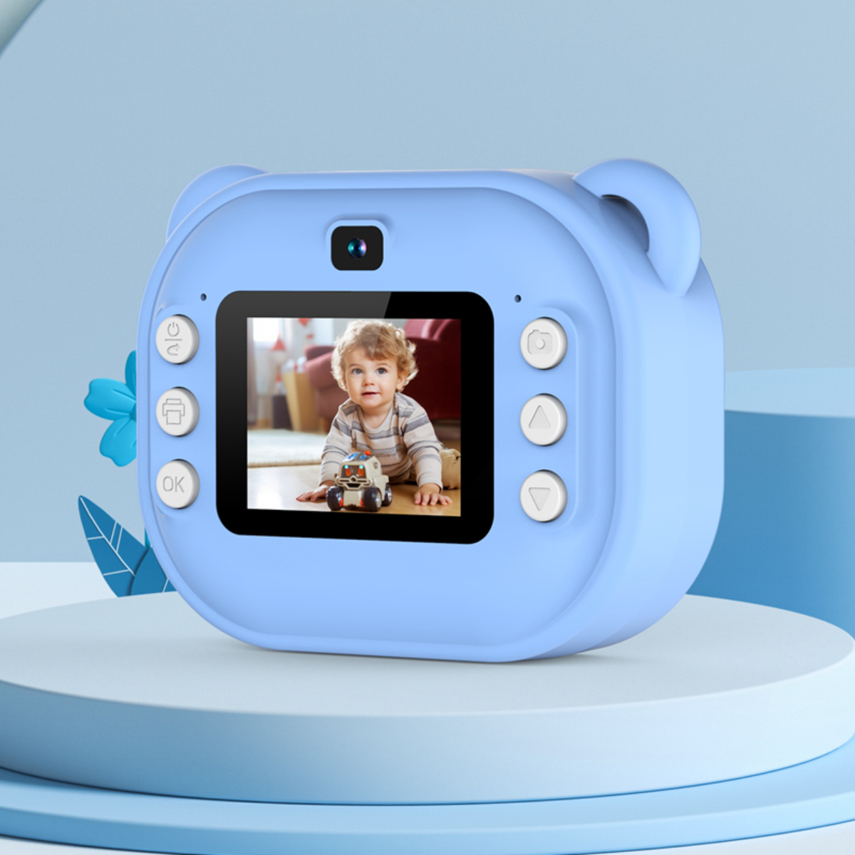 Blaue Kamera in Bärenform mit Babyfoto auf dem Bildschirm. Auf einem weiß-blauen Ständer platziert.