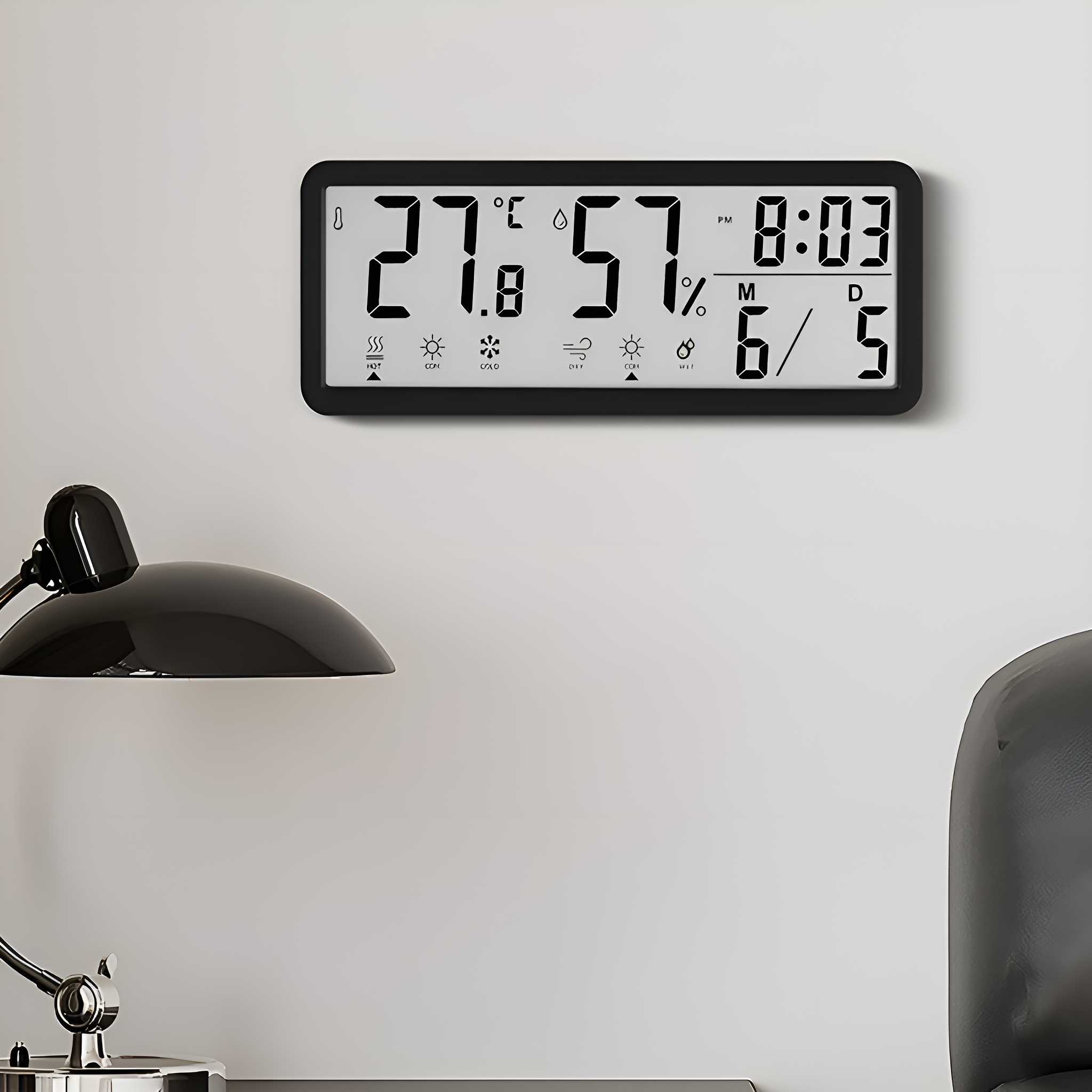 Eine schwarze Digitaluhr an einer weißen Wand. Sie zeigt Temperatur, Uhrzeit und Datum an.