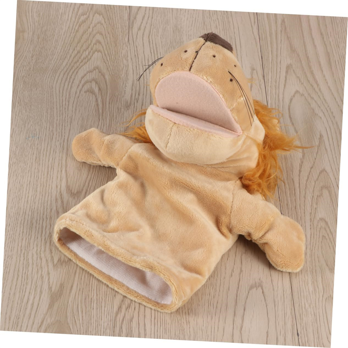 Eine Löwenhandpuppe in Beige liegt auf Holz. Sie hat einen offenen Mund und einen beigen Körper.