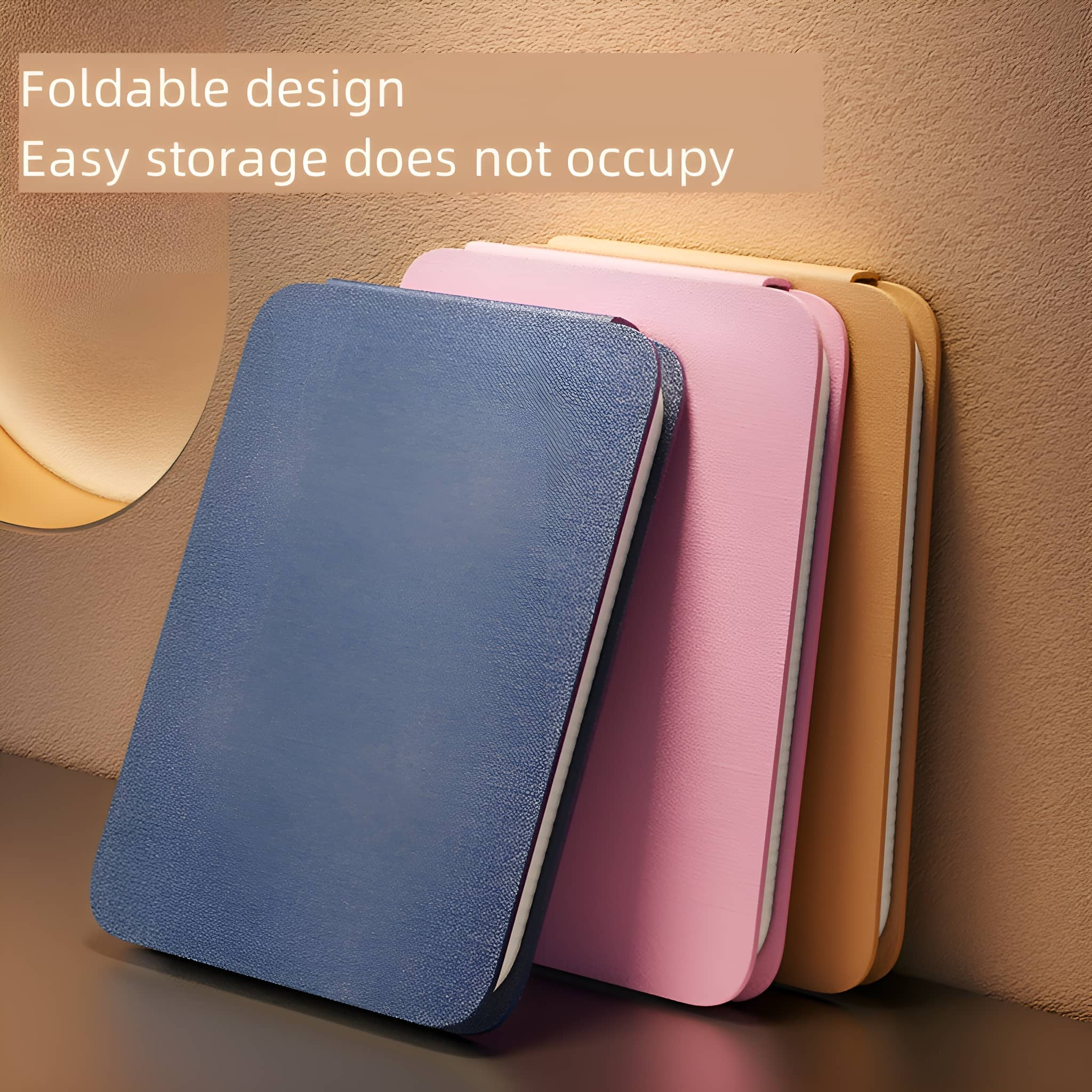 Drei zusammengefaltete Tablet-Hüllen in Blau, Rosa und Beige, gestapelt neben einer Wand, faltbares Design.
