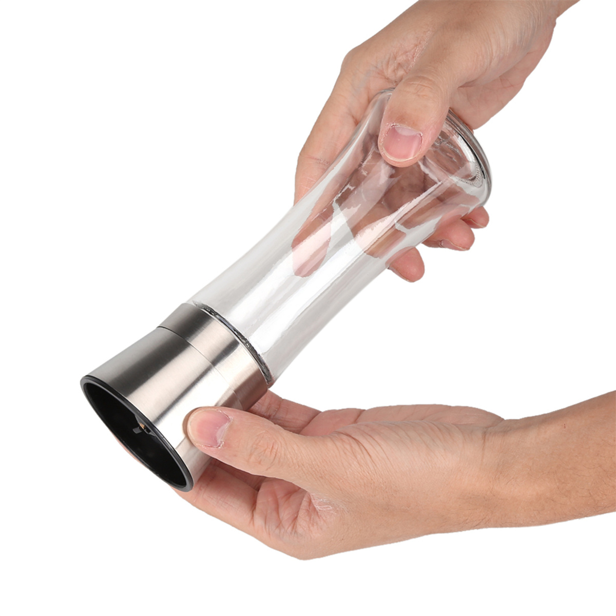 Hände halten eine klare Salzstreuer aus Glas mit Metallbasis. Der Streuer ist mit weißen Salzkristallen gefüllt.