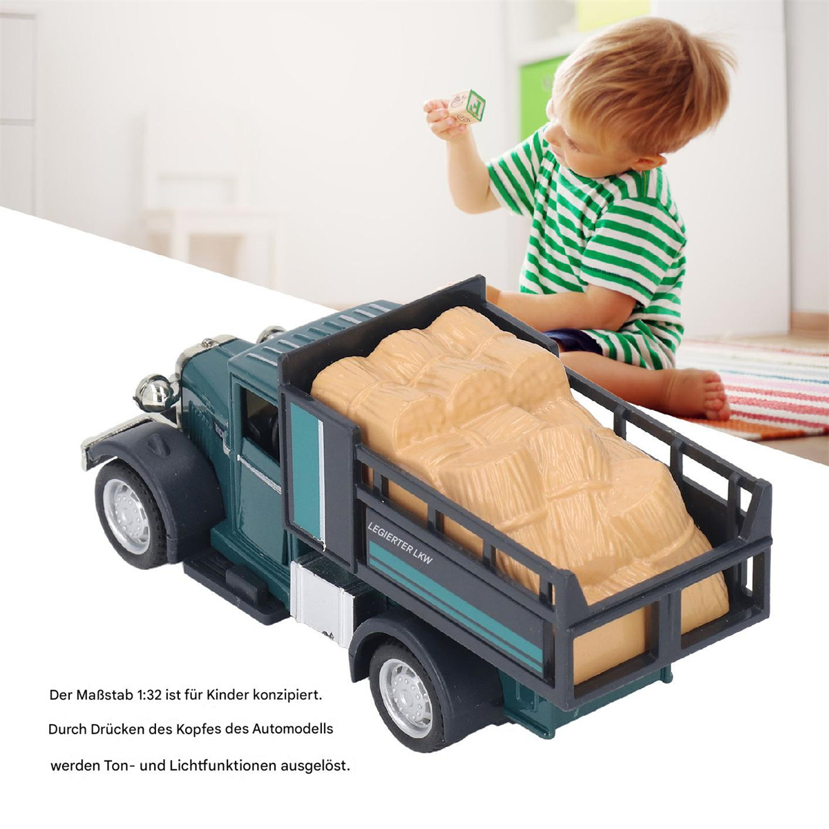 Ein grüner und schwarzer Spielzeug-LKW, der Heu transportiert. Ein Kind spielt im Hintergrund mit einem Block.