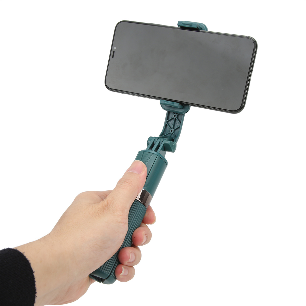 Hand, die einen grünen Selfie-Stick hält, mit einem schwarzen Telefon, weißer Hintergrund.