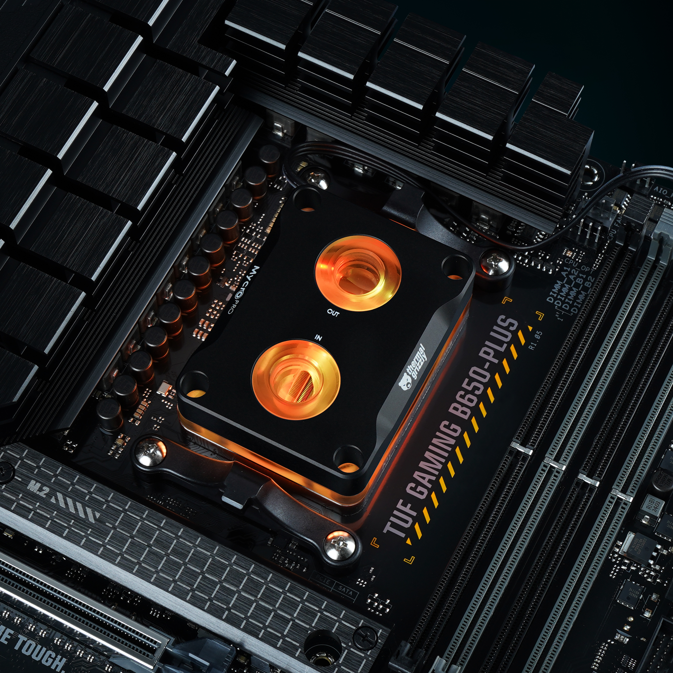 Eine schwarz-goldene Computerkomponente. Es ist ein Wasserkühlblock mit zwei goldenen Kreisen, der Hintergrund ist dunkel.