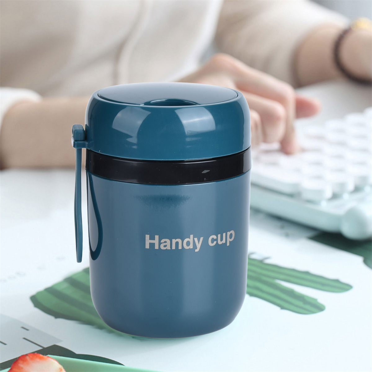 Ein blauer isolierter Lebensmittelbehälter mit dem Wort "Handy cup".