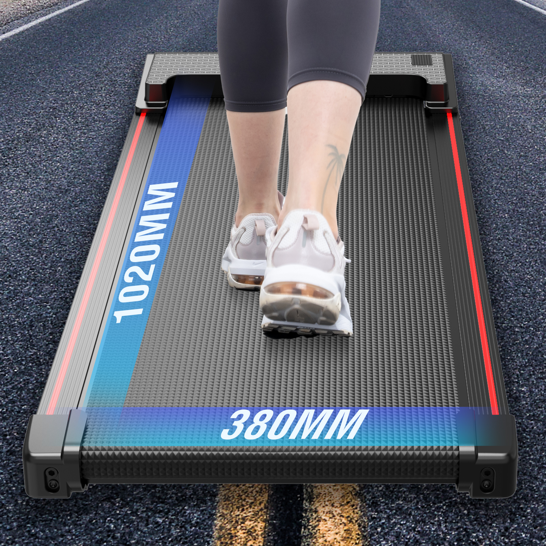 Eine Person geht auf einem schwarzen Laufband mit blauen und roten Akzenten. Das Laufband steht auf einer Asphaltstraße. Wort '1020MM' sichtbar.