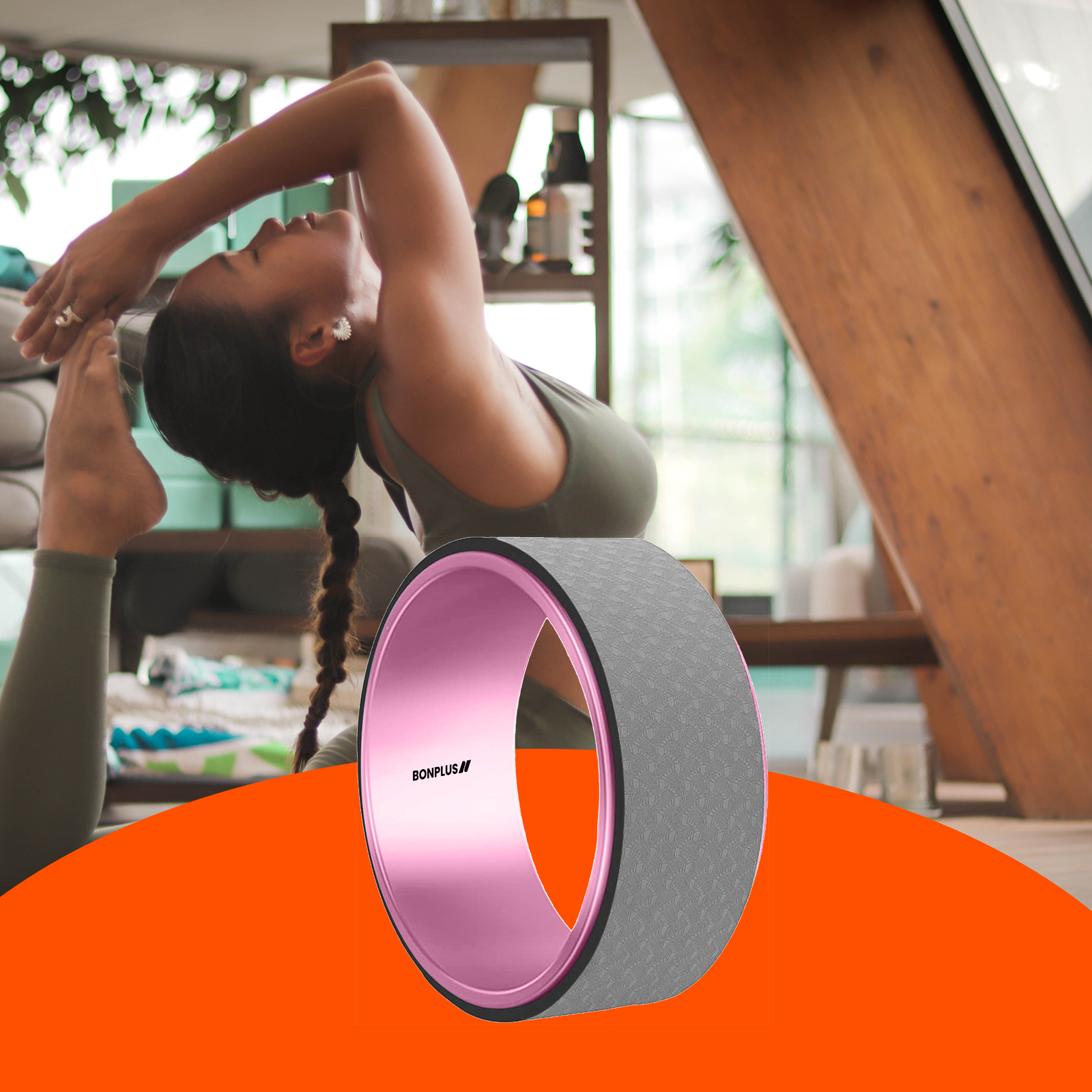 Mujer haciendo yoga con una rueda rosa y gris. El fondo incluye una ventana y vigas de madera.