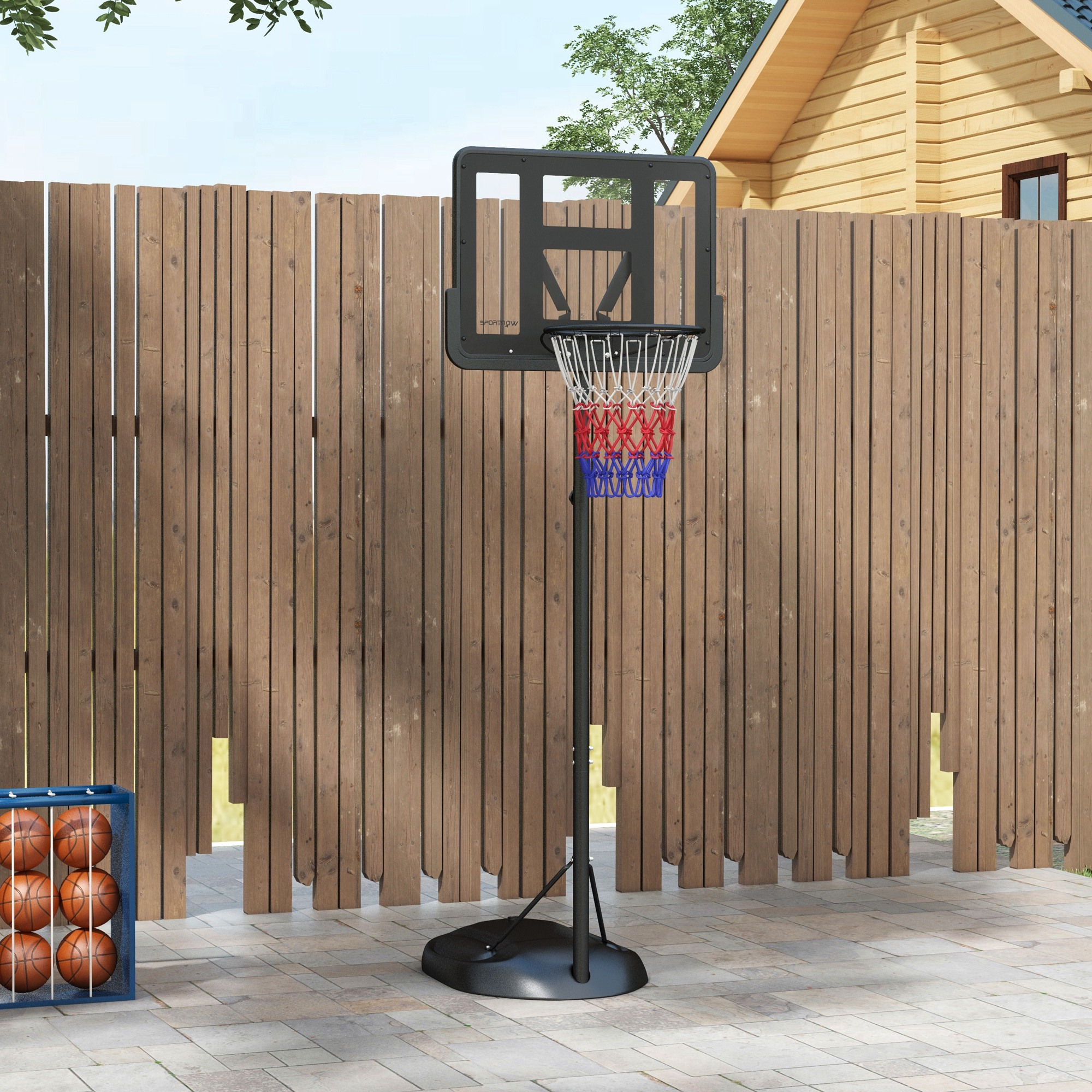 Un aro de baloncesto se encuentra frente a una valla de madera. Una caja azul contiene balones a la izquierda.