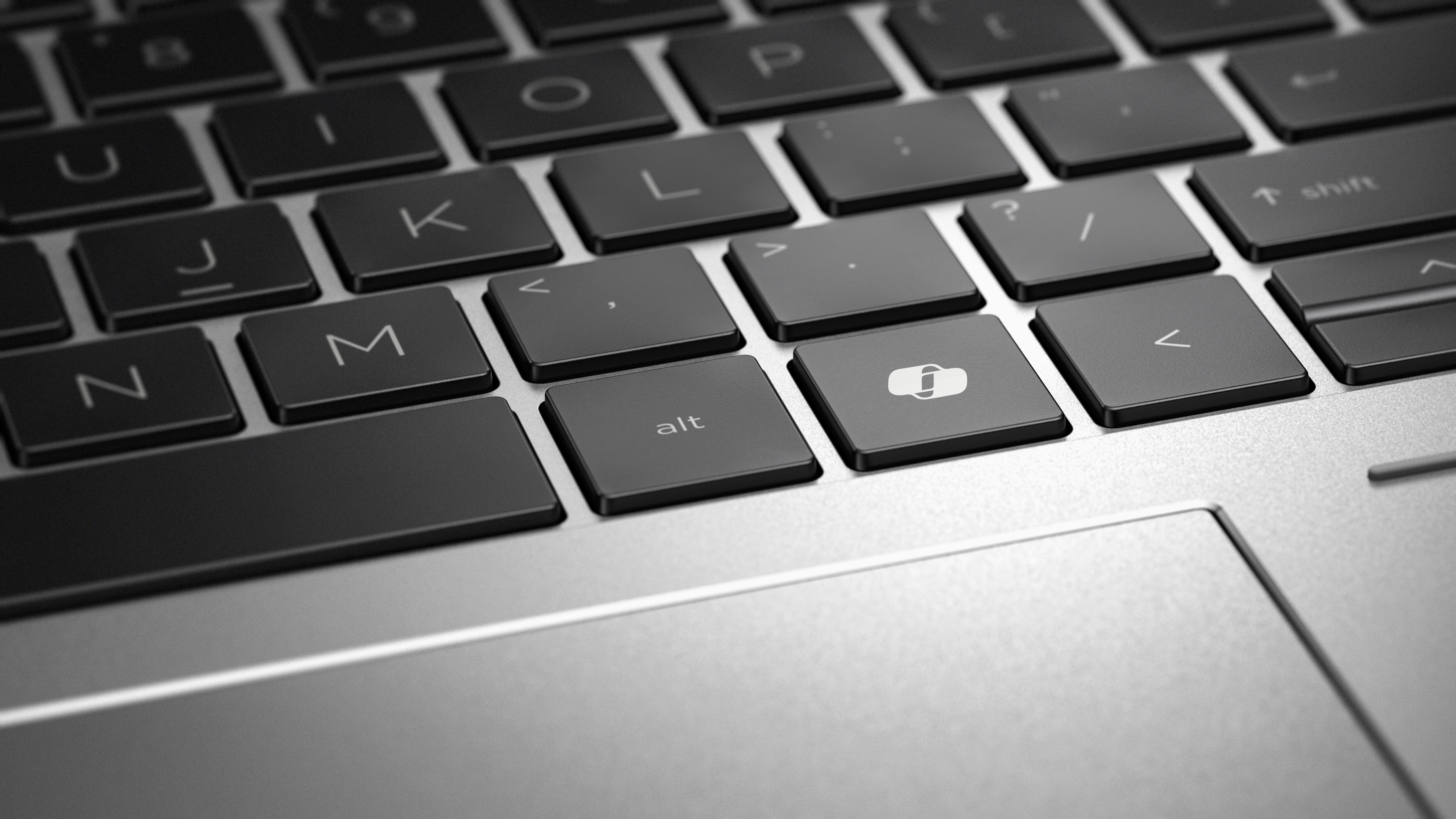 Nahaufnahme einer Laptop-Tastatur mit schwarzen Tasten und silbernem Rahmen, Fokus auf 'alt'.