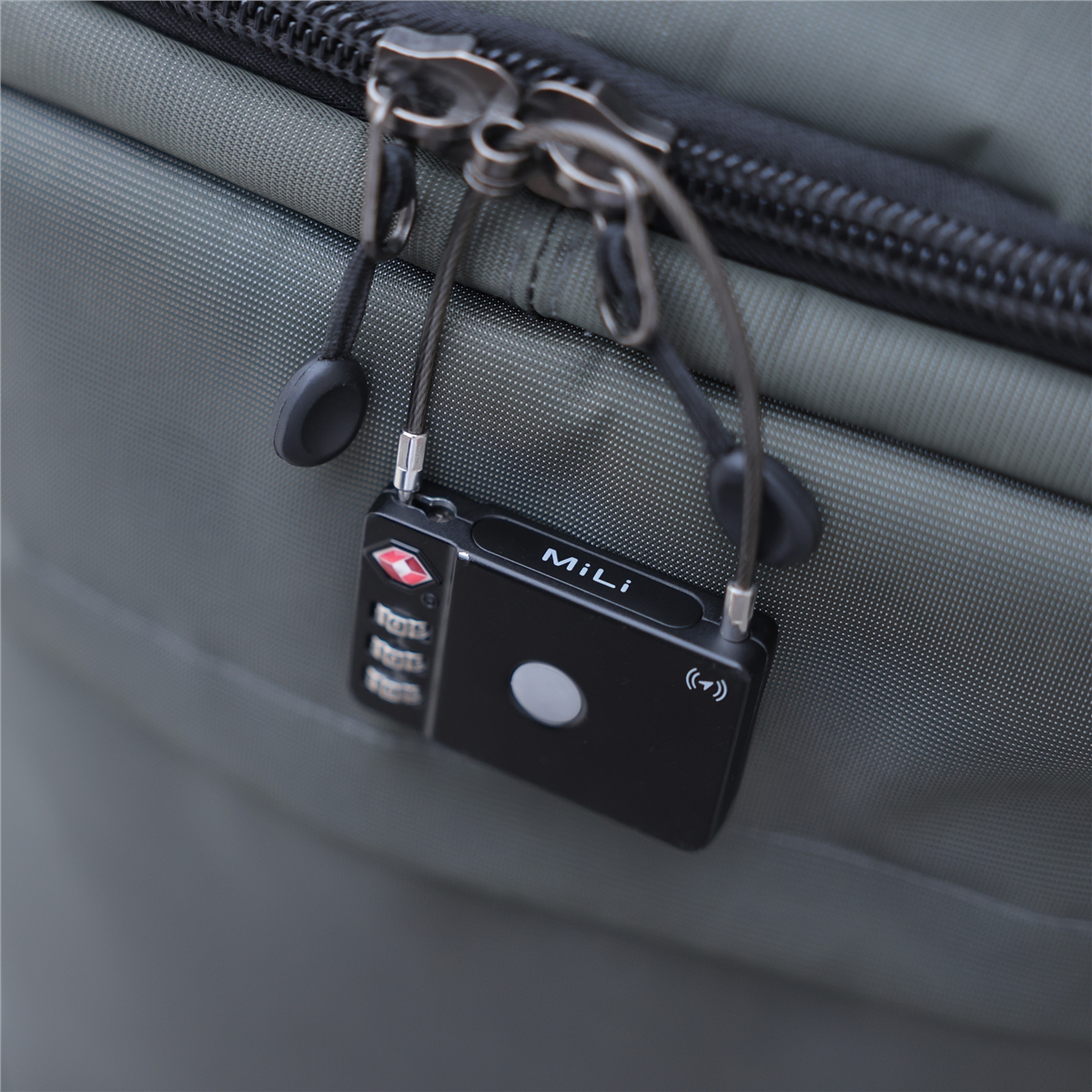 Black combination lock on a gray bag. It features a digital display and a TSA-approved logo.