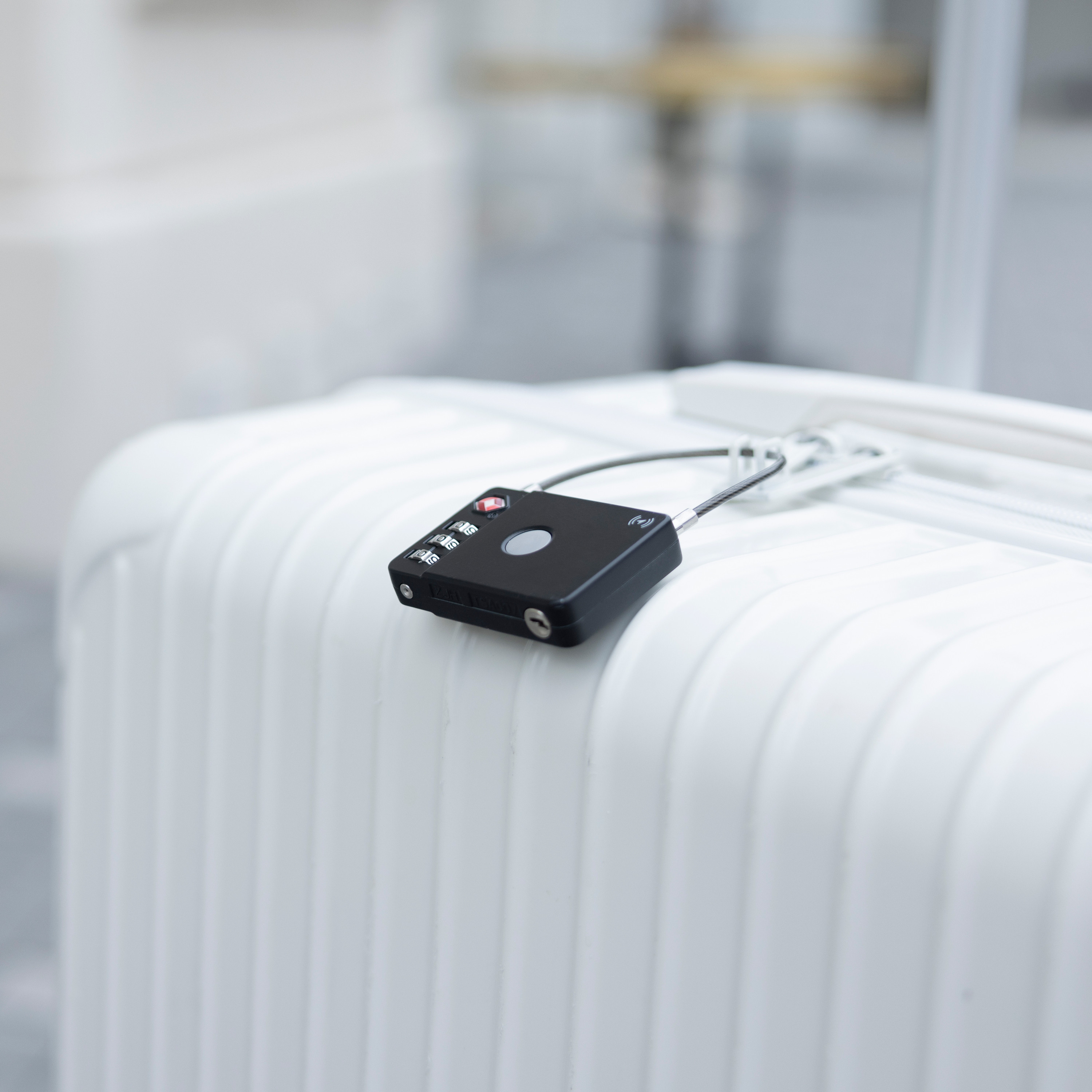 White suitcase with a black lock on it.