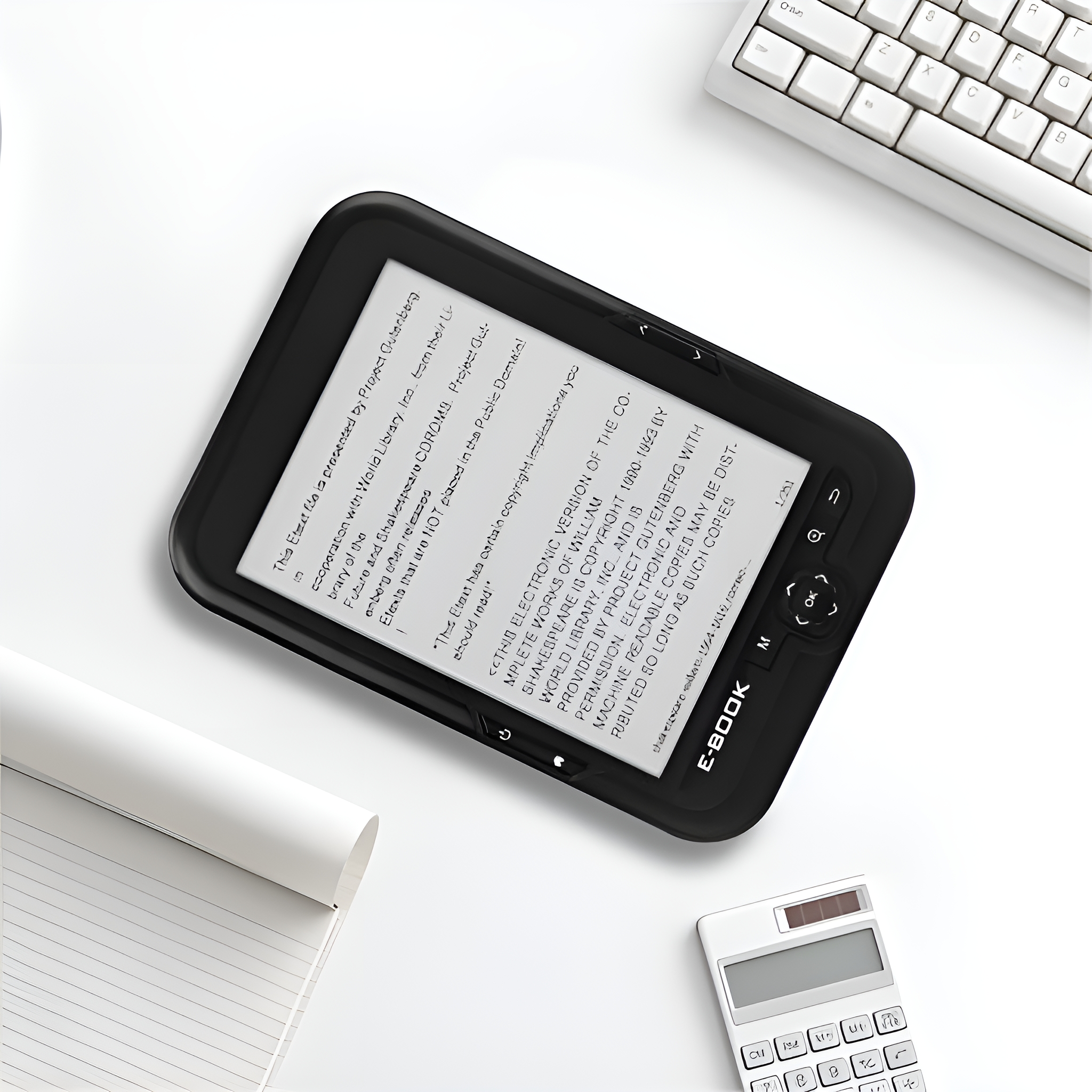 Ein E-Reader auf einer weißen Oberfläche mit Notizblock, Taschenrechner und Tastatur.