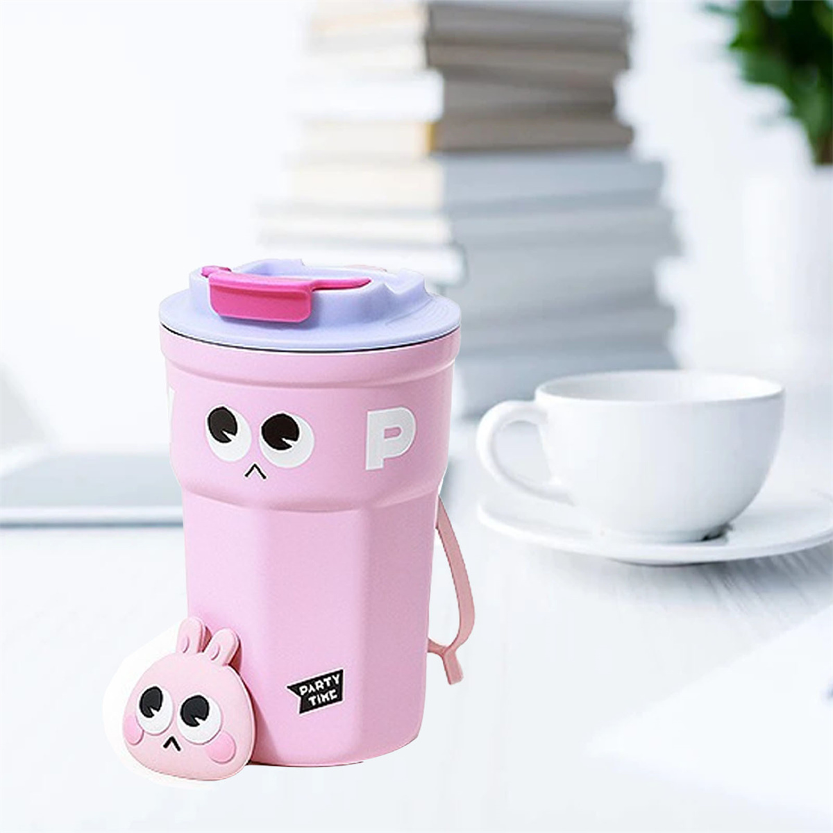 Rosa Cartoon-Becher mit Deckel und Hasenaufsatz. Ein weißer Becher im Hintergrund.