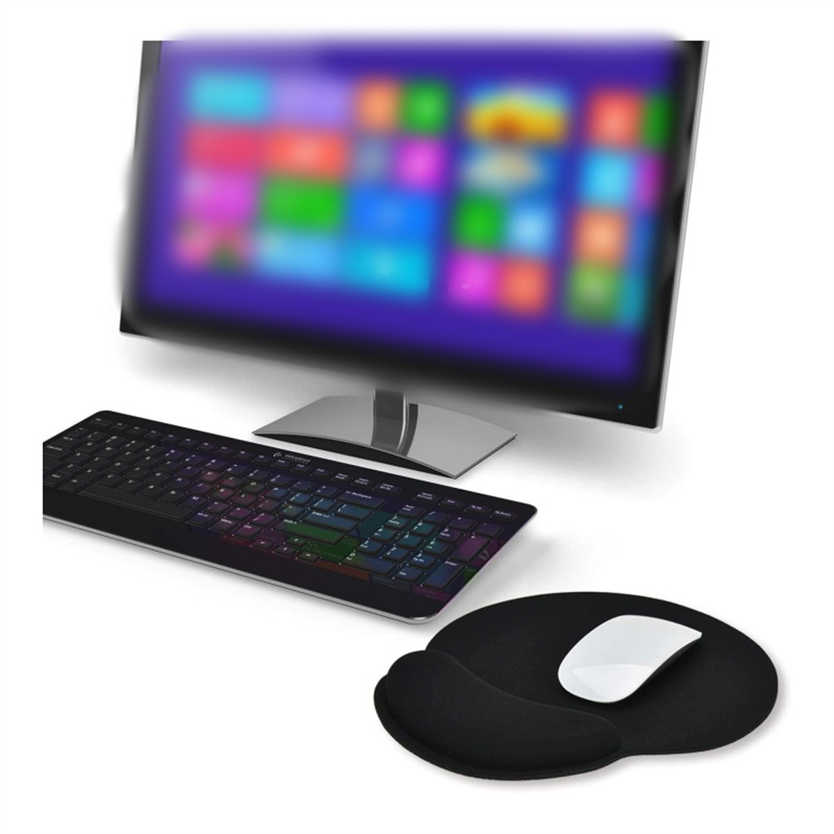 Schwarze Tastatur mit bunten Tasten, Maus und Mauspad auf einem Tisch mit Monitor im Hintergrund.