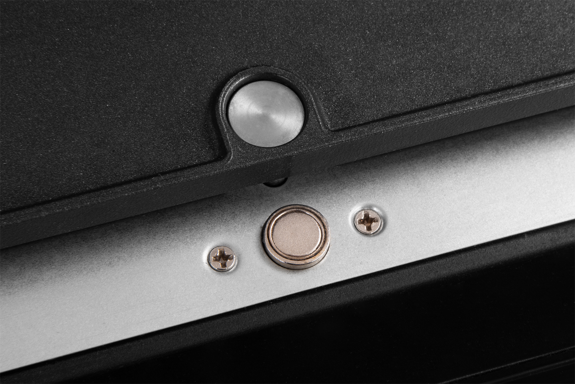 Primo piano: due viti e un magnete su una superficie metallica.