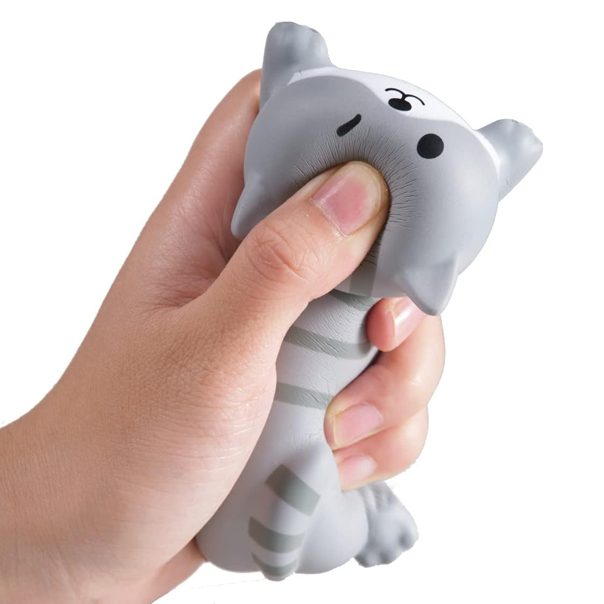Hand, die einen grauen, katzenförmigen Stressball zusammendrückt. Katze hat schwarze Augen und Streifen. Weißer Hintergrund.