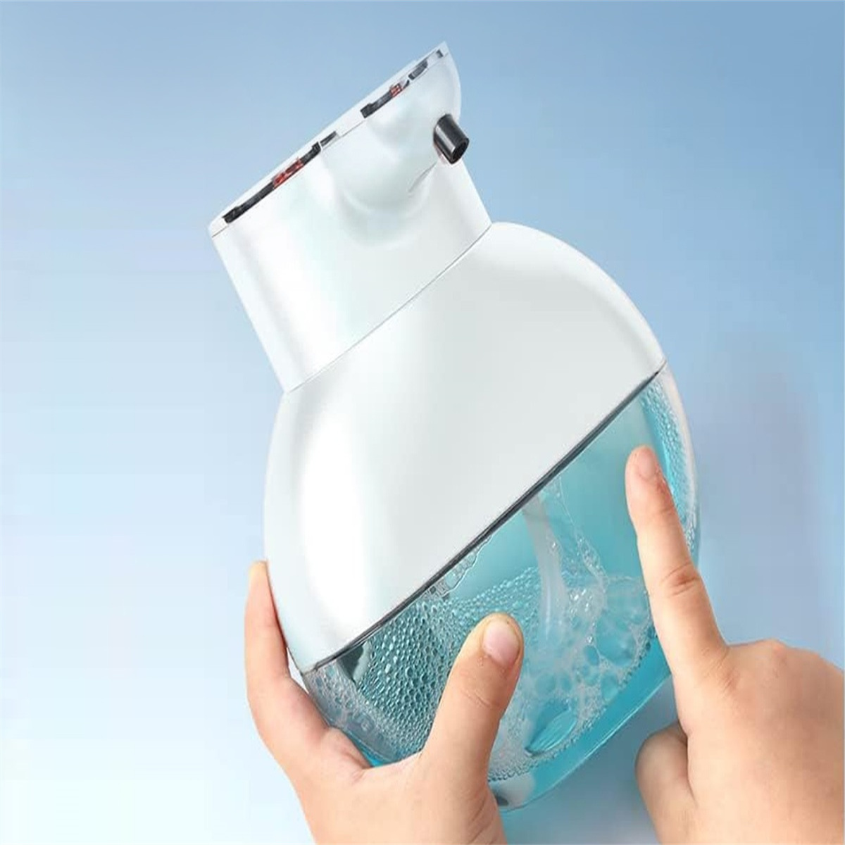 Ein weißer und blauer automatischer Seifenspender. Eine Hand drückt den Sensor, um die Seife abzugeben.