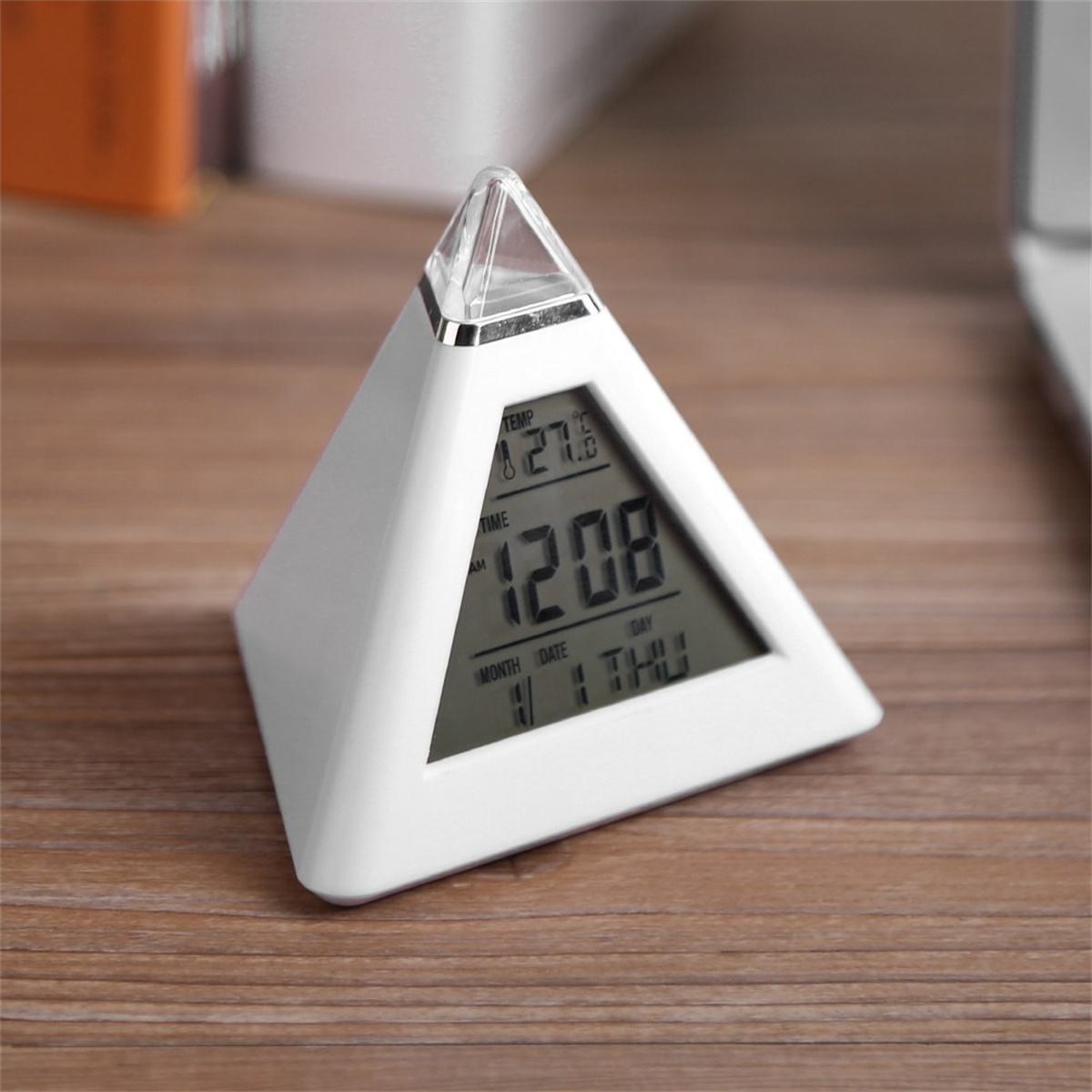 Weißer pyramidenförmiger Digitalwecker mit Uhrzeit, Datum und Temperatur.