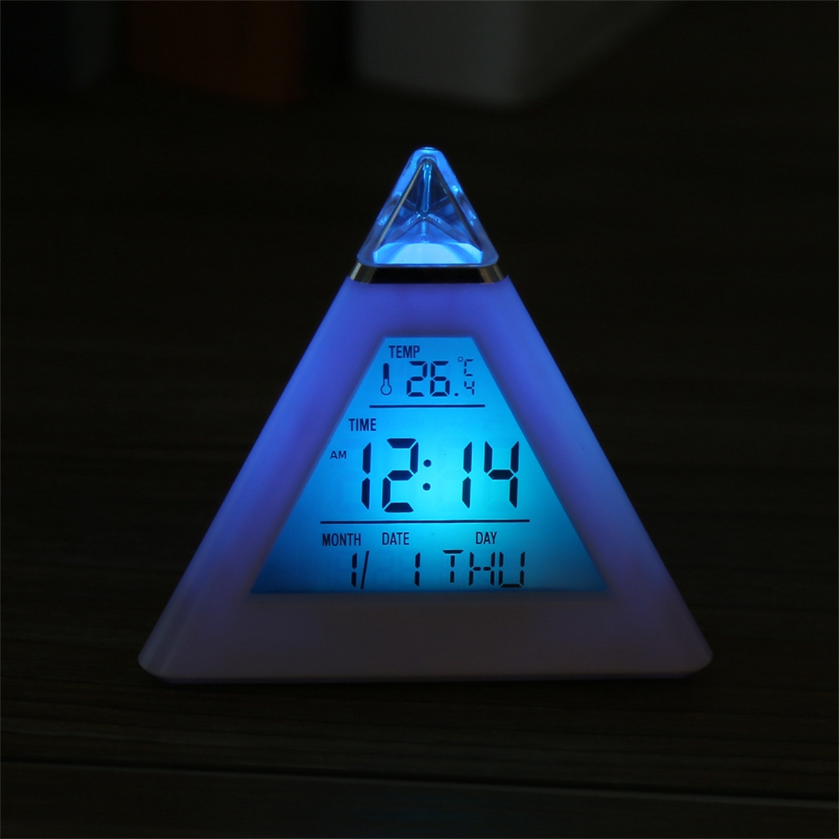 Ein dreieckiger digitaler Wecker, der Zeit und Datum anzeigt, blau leuchtend.