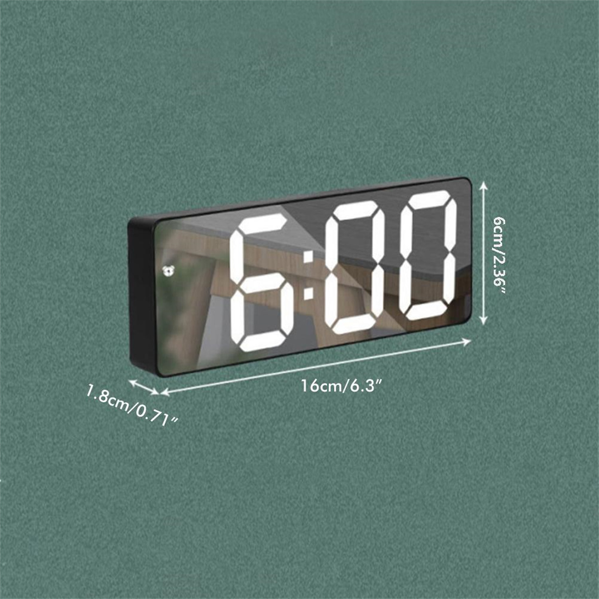 Ein digitaler Wecker zeigt 6:00 Uhr an. Es hat einen schwarzen Rahmen und weiße Zahlen. Die Abmessungen sind sichtbar.
