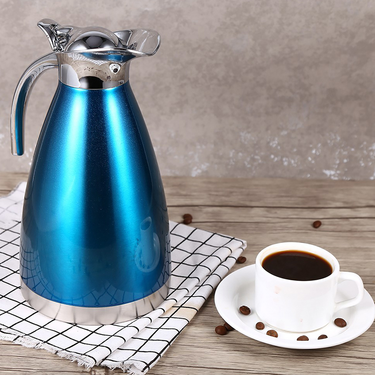Blaue Thermoskanne, weiße Tasse mit Kaffee und Untertasse auf karierter Serviette. Kaffeebohnen.