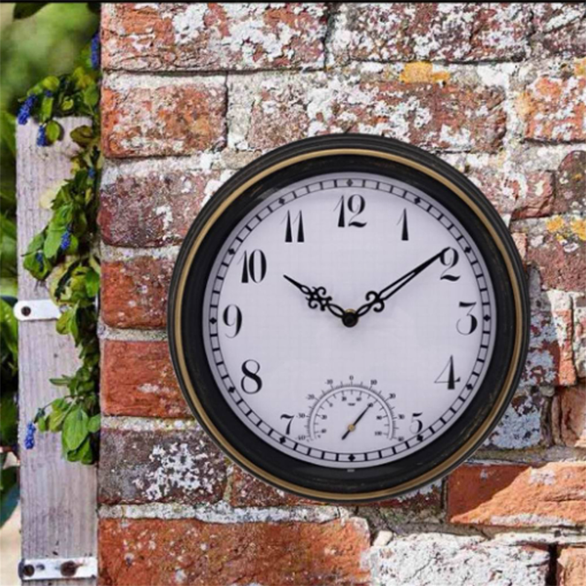 Eine runde Wanduhr mit schwarzem Rahmen, an einer Ziegelmauer befestigt. Die Uhr hat römische Ziffern.