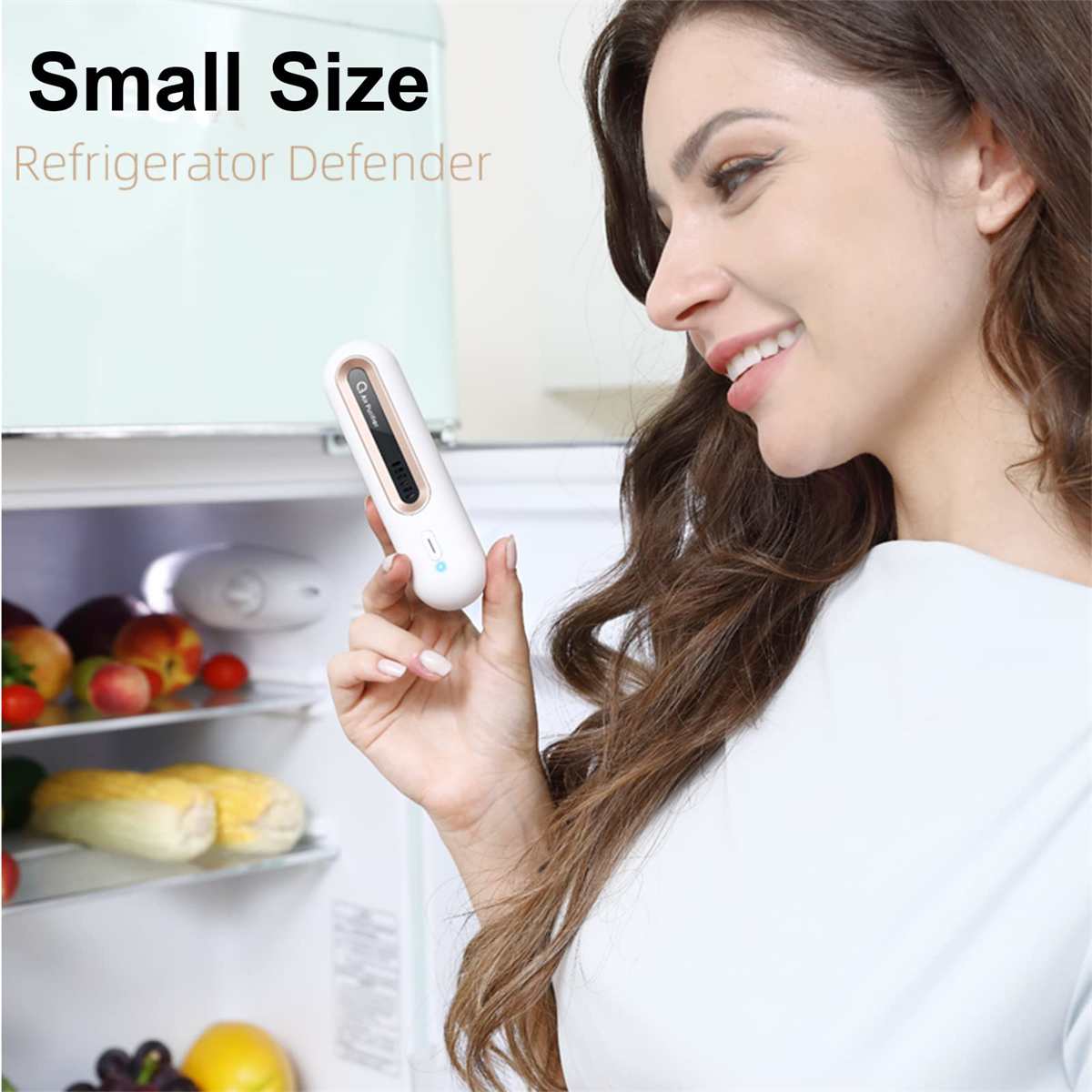 Eine Frau hält einen kleinen, weißen Kühlschrankverteidiger vor einem Kühlschrank.