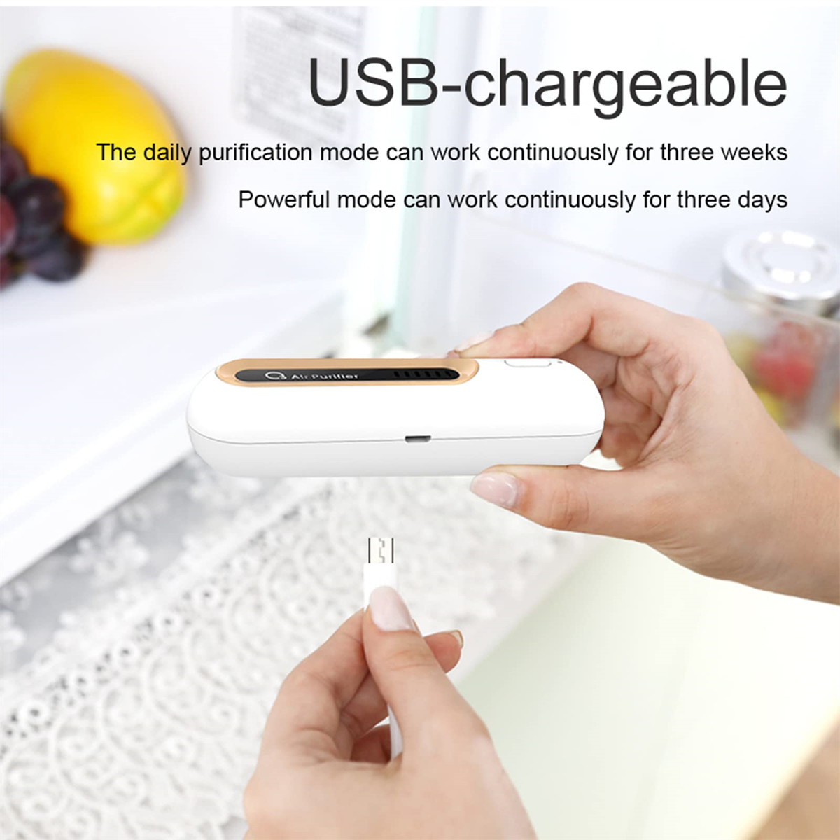 Ein weißer Luftreiniger mit USB-Kabel. Eine Hand hält das Kabel zum Reiniger.