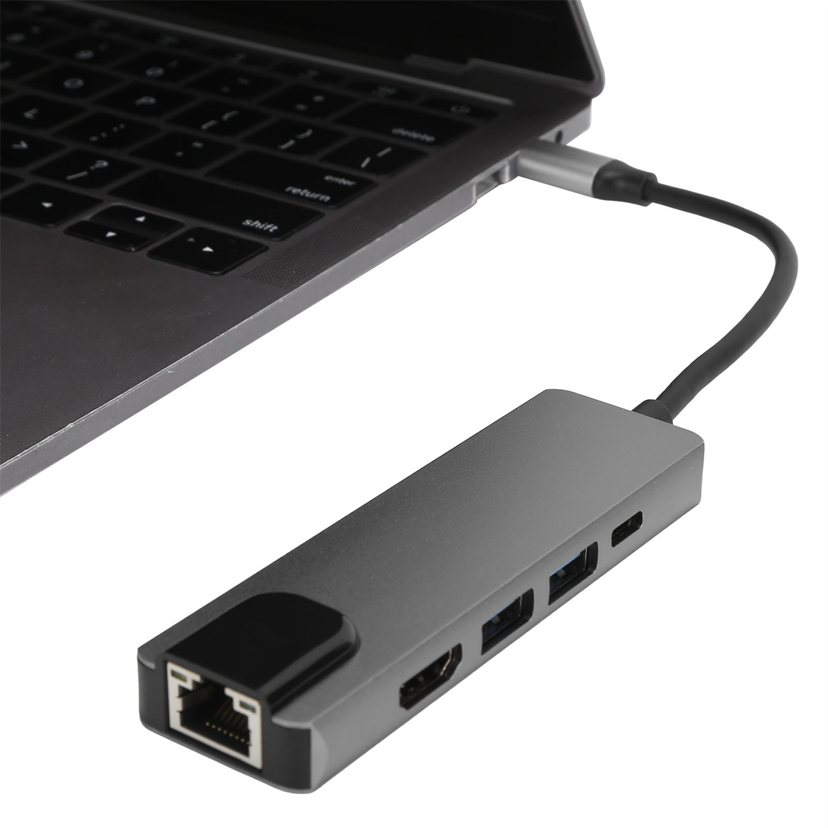 Ein silberner und grauer USB-Hub, der mit einem Laptop verbunden ist. Er hat mehrere Anschlüsse: USB, HDMI und Ethernet.