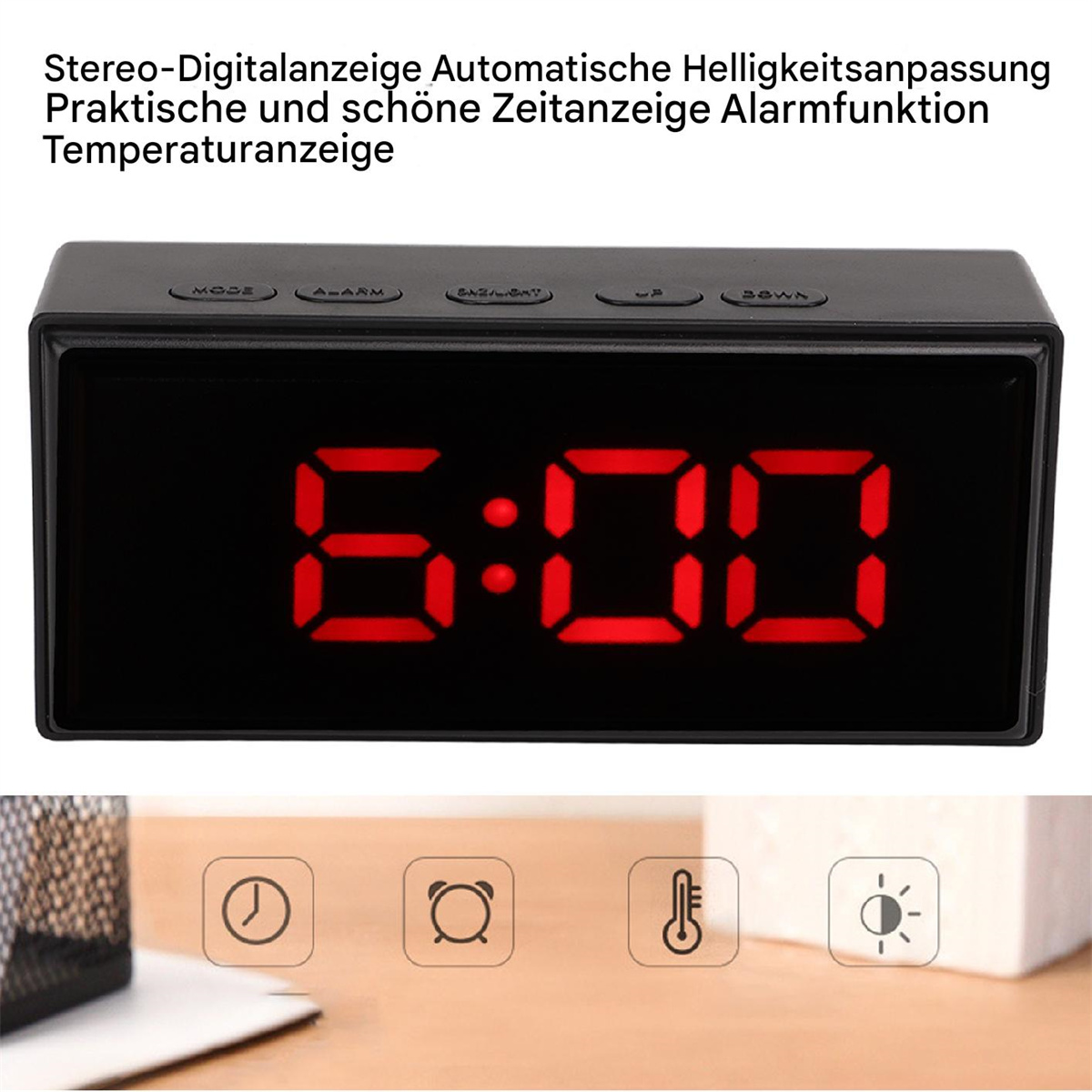 Ein schwarzer digitaler Wecker, der 6:00 in roten Ziffern anzeigt. Die Tasten sind mit MODE, ALARM, SNOOZE/LIGHT, UP und DOWN beschriftet.