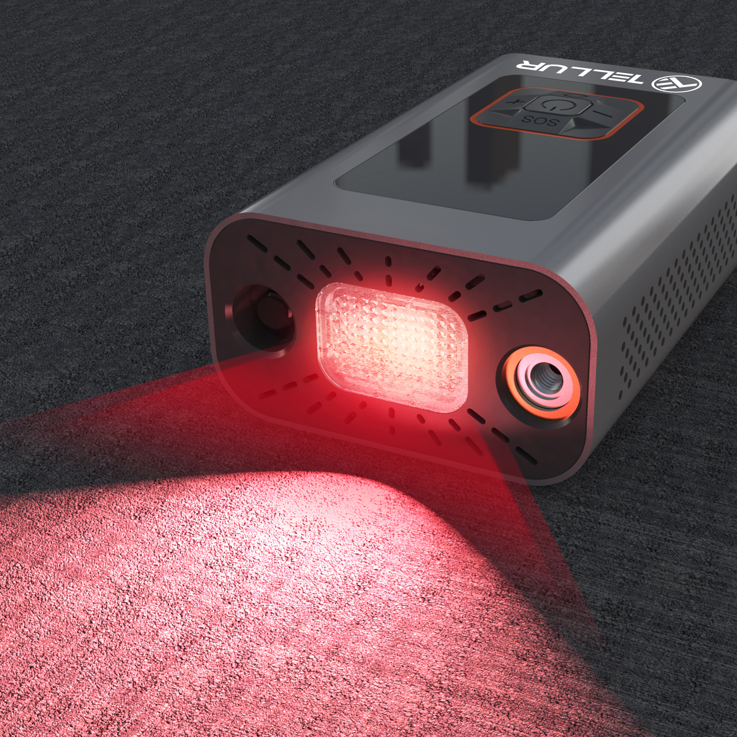 Czarno-szara latarka. Czerwona wiązka światła wychodząca z przodu. Czarna powierzchnia.