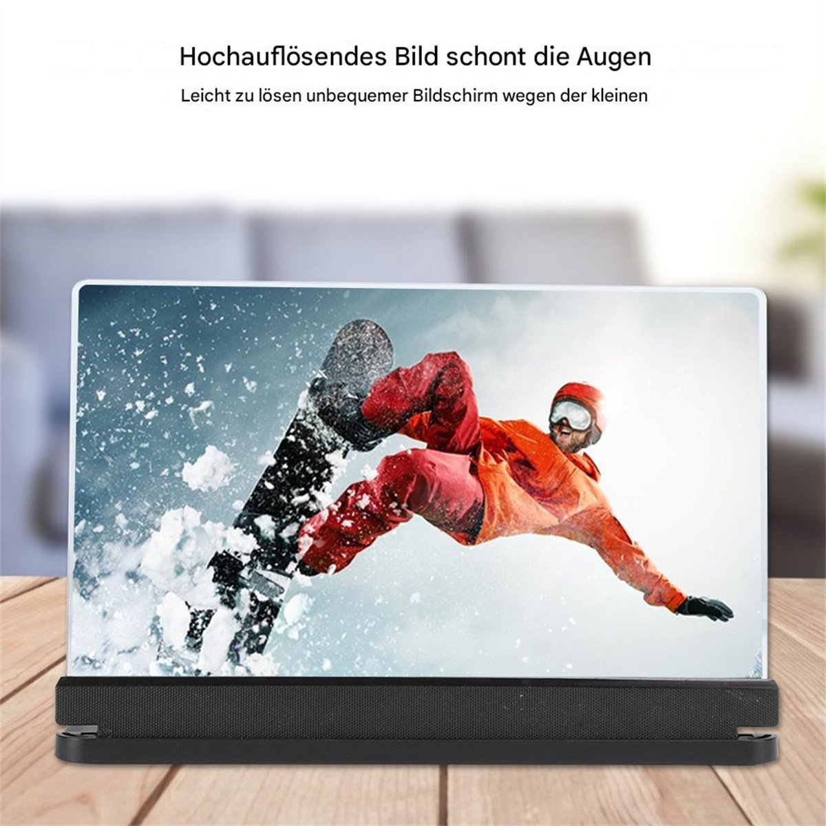 Ein Bildschirm mit einem Skifahrer auf einer schneebedeckten Piste auf einem Holztisch.