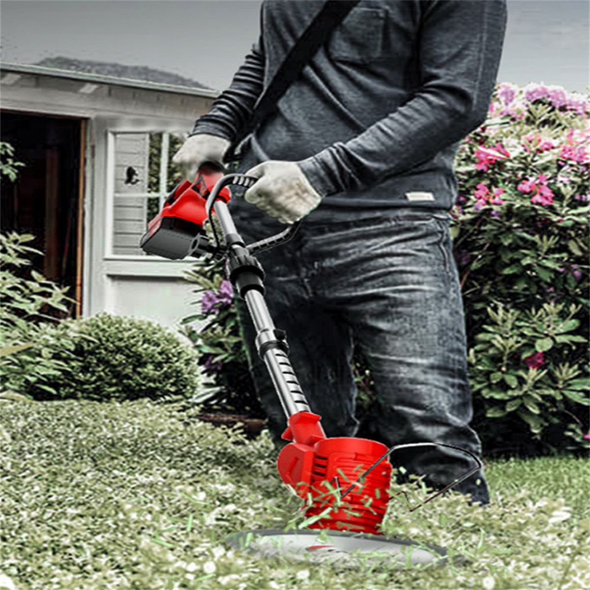 Ein Mann trimmt Gras mit einem roten elektrischen Trimmer in einem Garten, trägt Handschuhe und Jeans.
