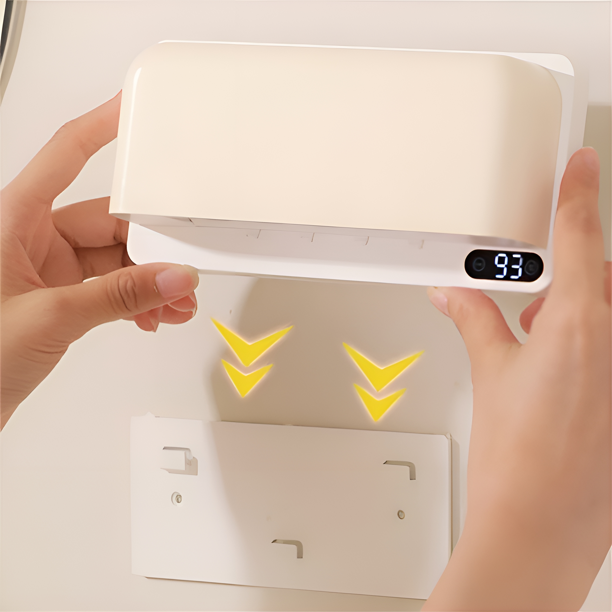 Hände montieren einen weißen, an der Wand befestigten UV-Sterilisator mit Digitalanzeige.