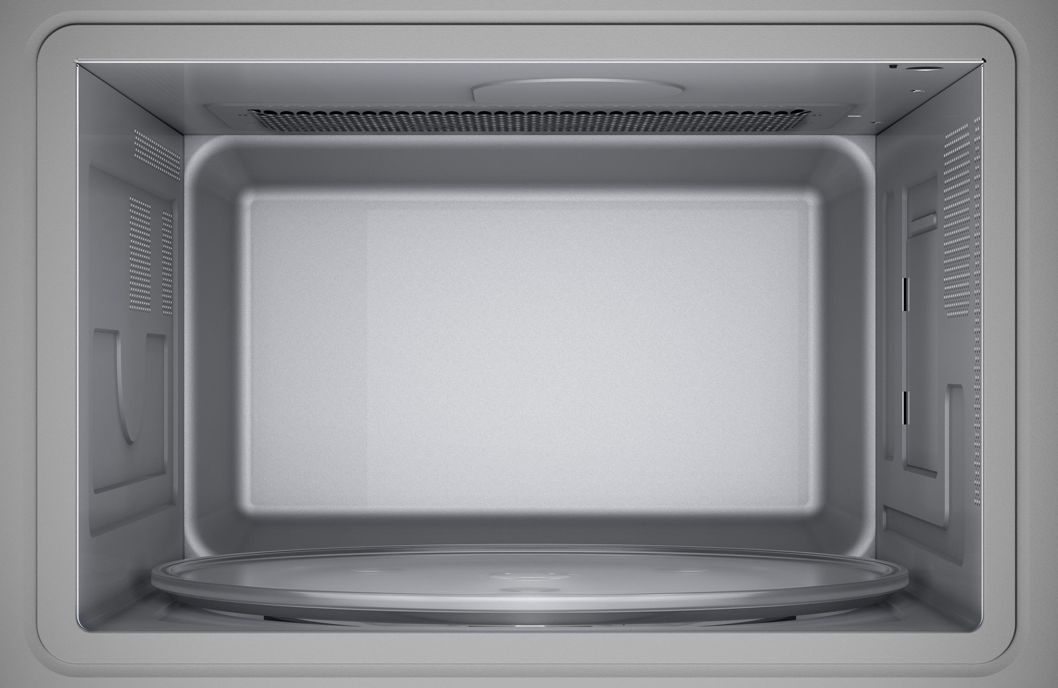 Widoczne wnętrze kuchenki mikrofalowej, ze szklanym talerzem i białym wnętrzem.