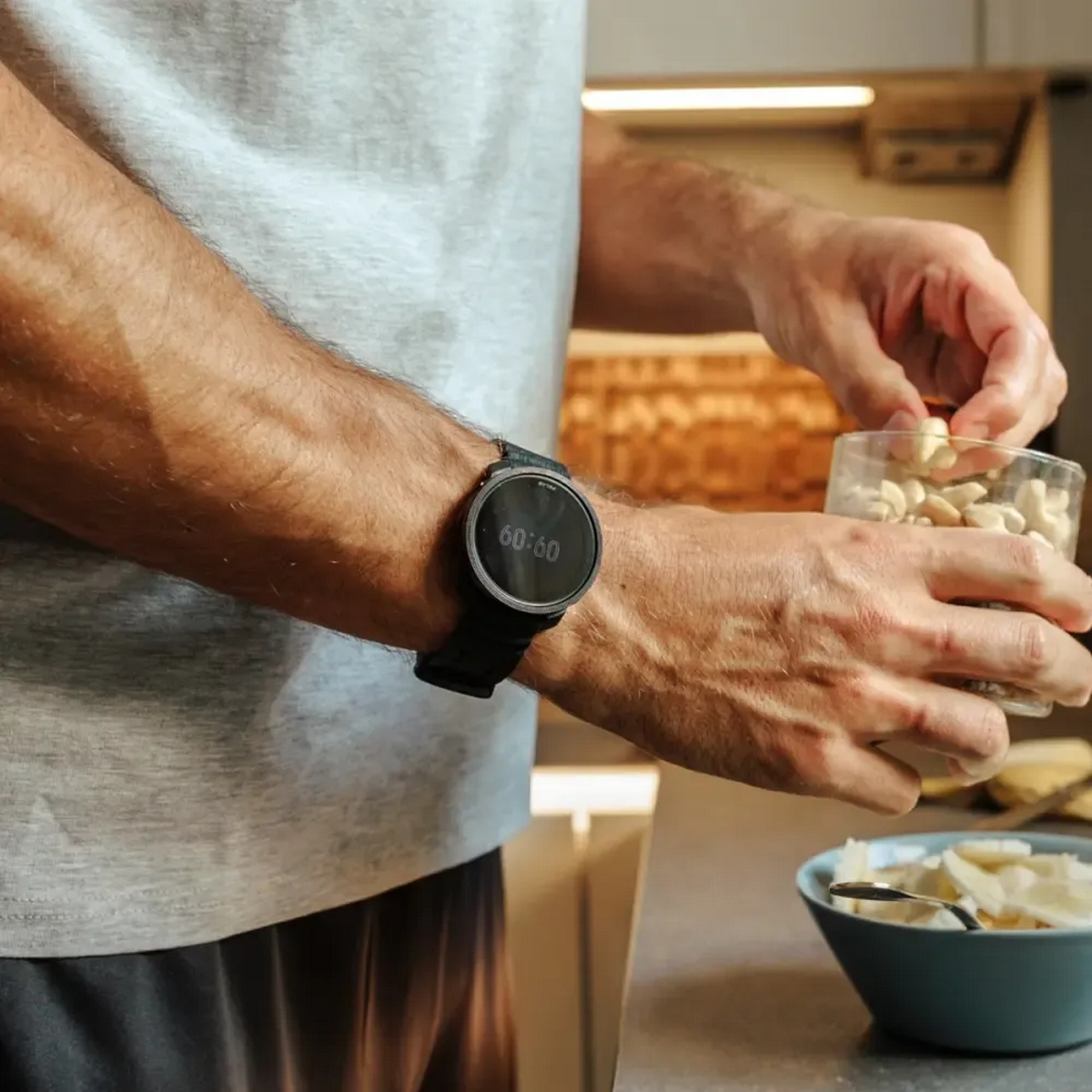 Mężczyzna z inteligentnym zegarkiem z czarnym paskiem, w kuchni.