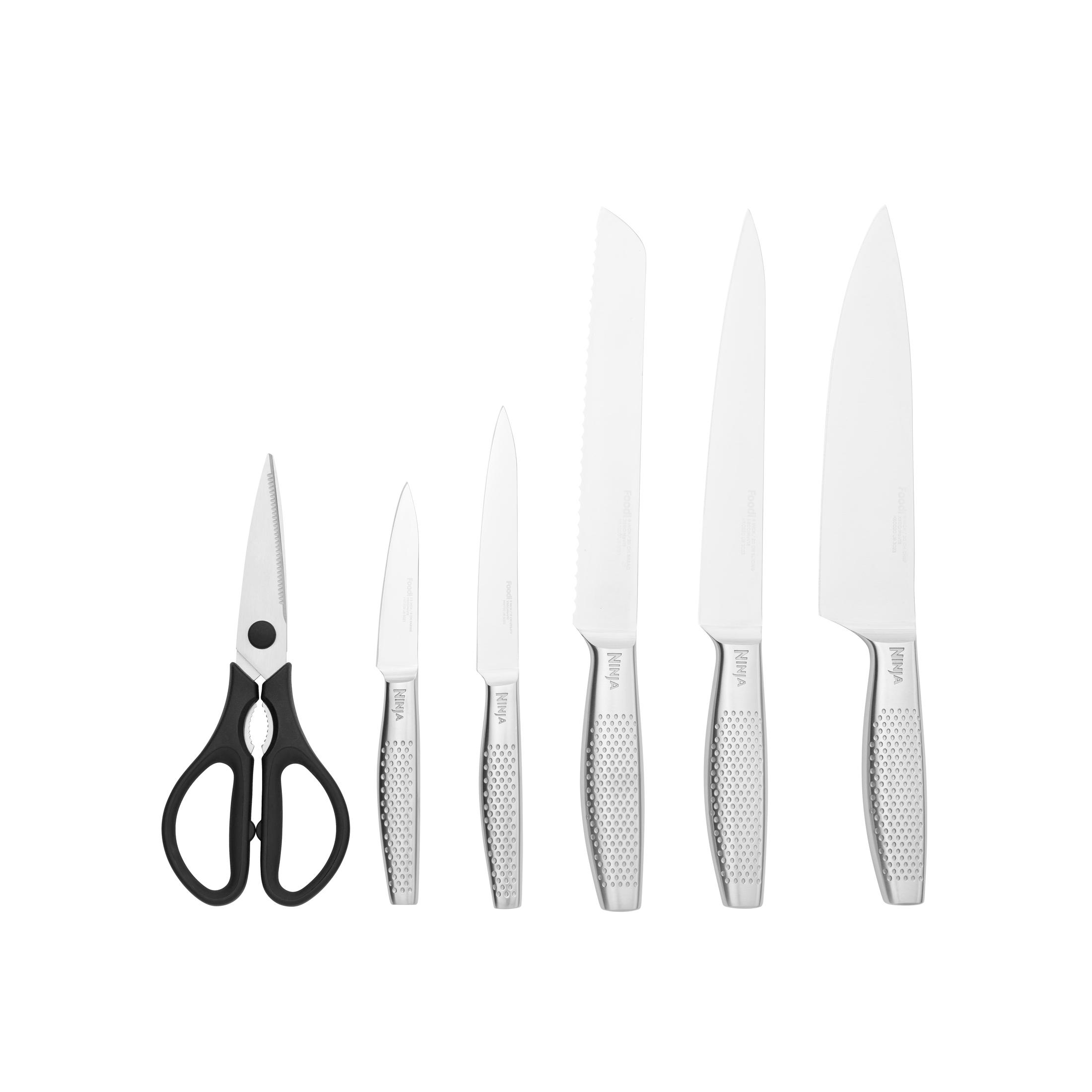 Ein Set aus sechs silbernen Küchenmessern und Scheren mit schwarzen Griffen, angeordnet auf einer weißen Oberfläche.