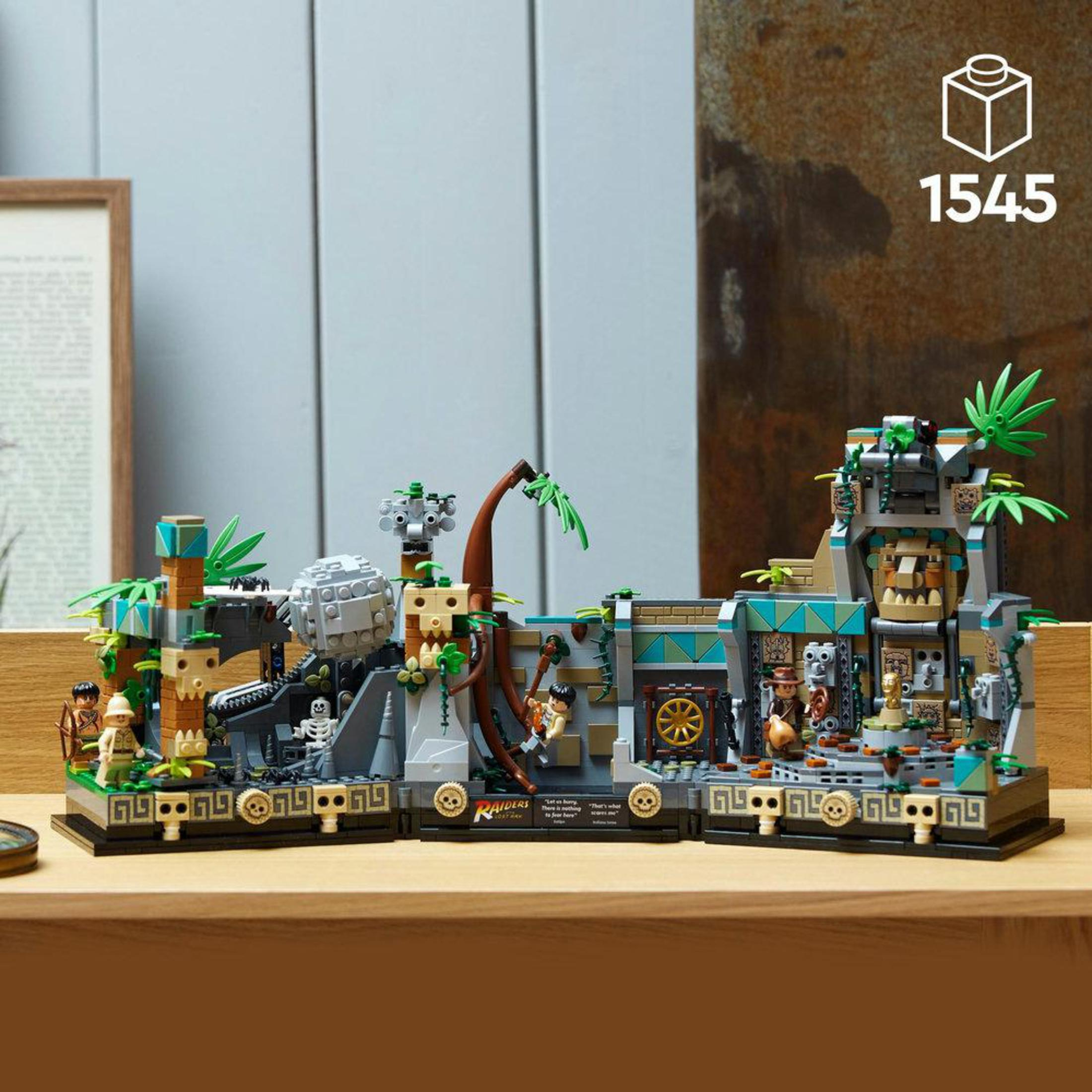 Lego-Set mit einer Tempelszene und Figuren. Es gibt einen Holztisch. 1545 Teile.