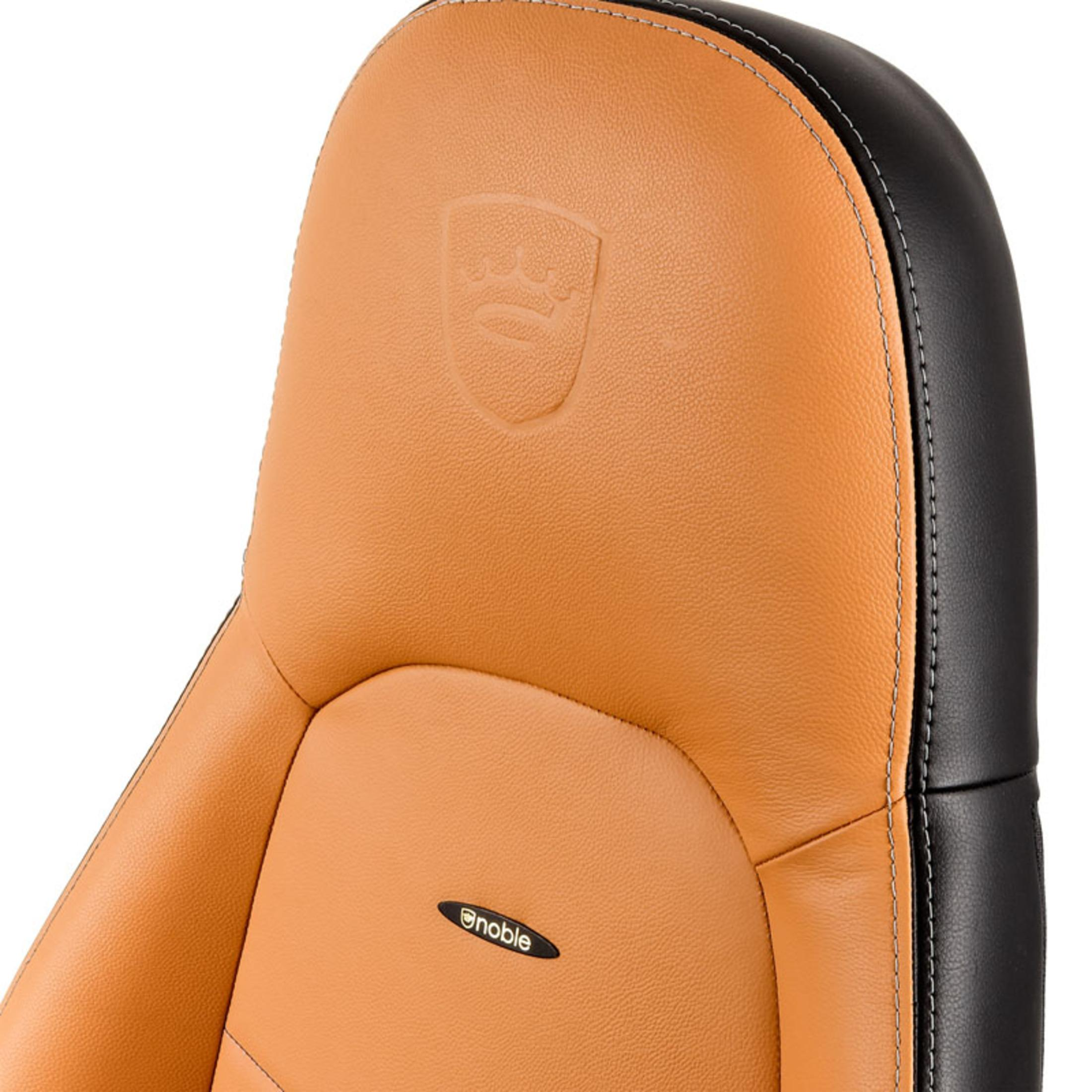 Close-up van een bruin en zwart autostoeltje. Noble-logo is zichtbaar op de hoofdsteun.