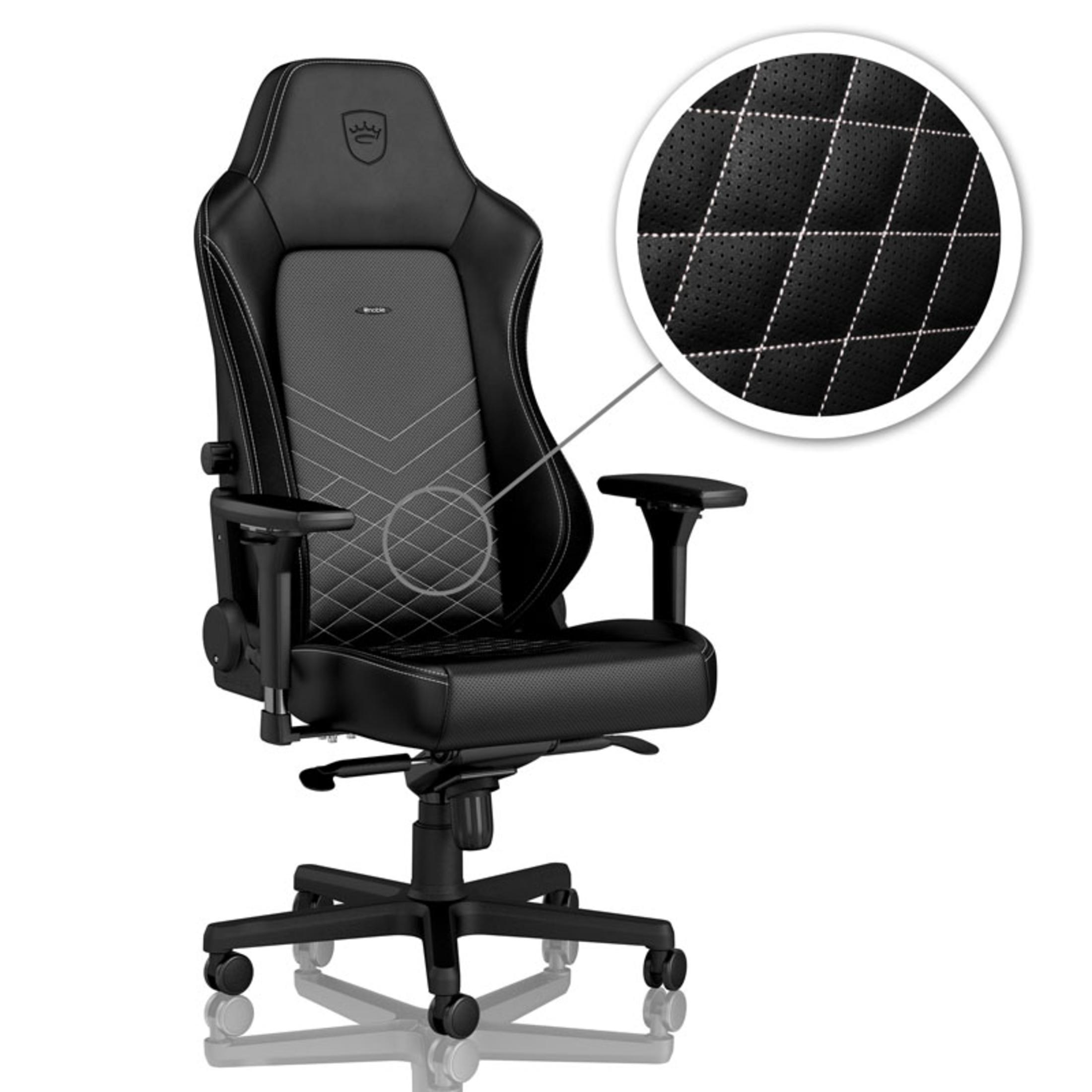 Sedia da gaming nera con cuciture bianche. Poggiatesta, braccioli e base a cinque ruote.