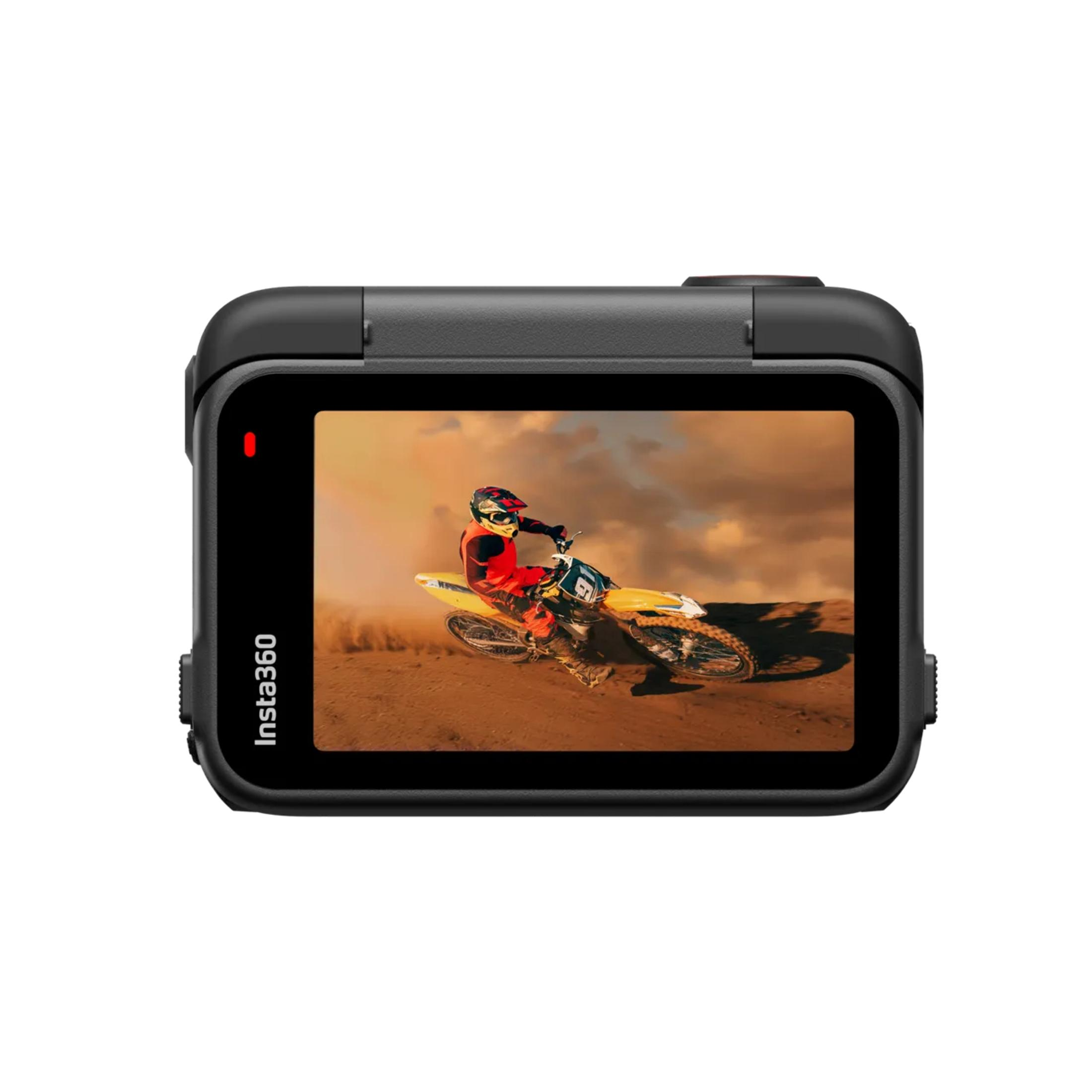 Kamera sportowa pokazująca zawodnika motocrossowego na motocyklu terenowym, wzbijającego kurz, w słoneczny dzień.