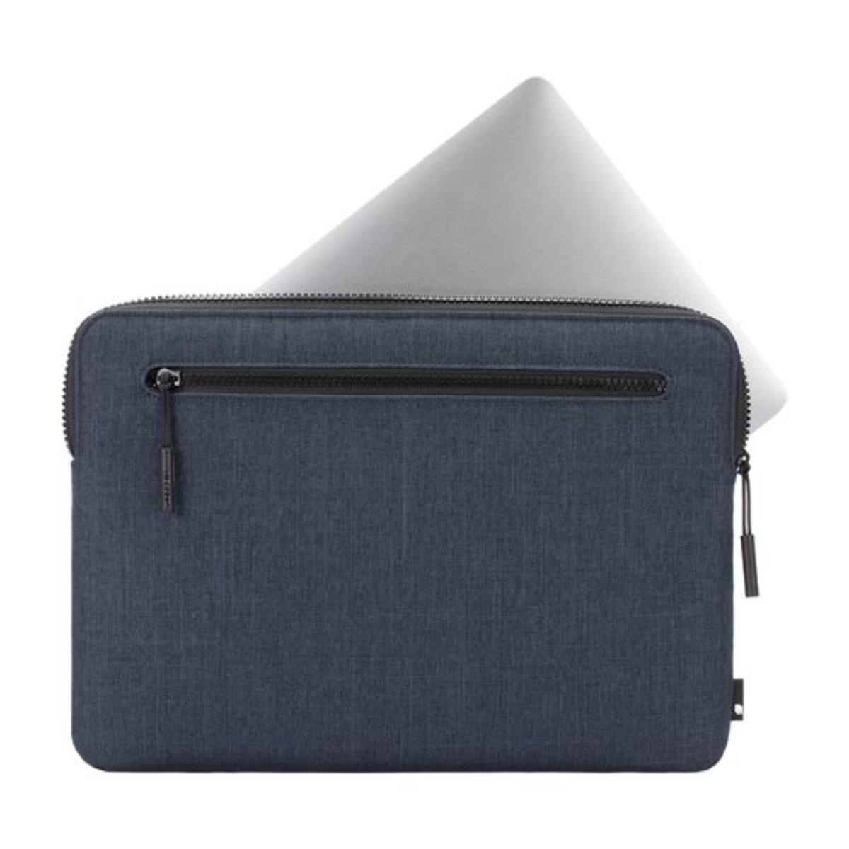 Una custodia per laptop blu navy con cerniera, che contiene un laptop argentato. Il laptop è parzialmente visibile.