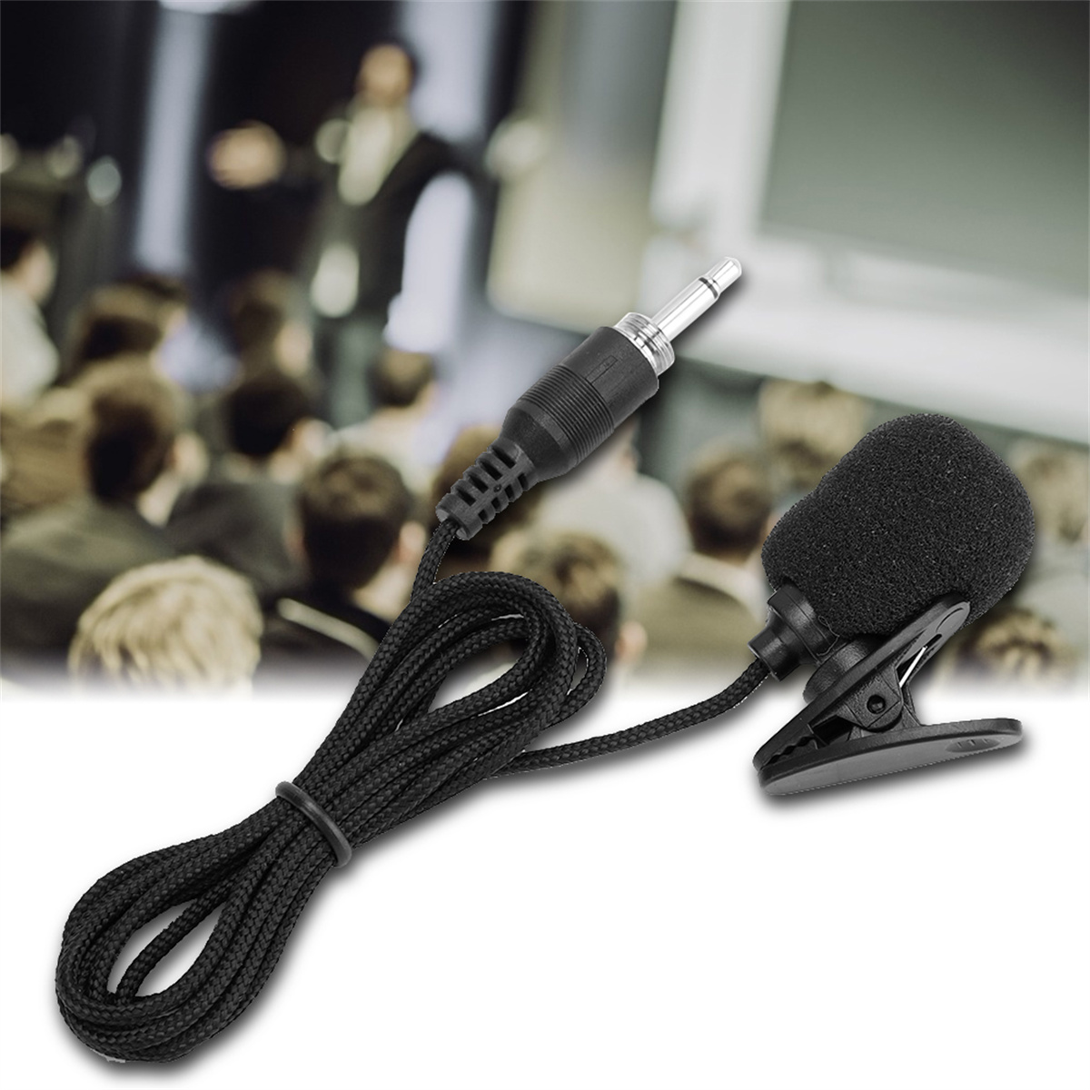 Schwarzes Ansteckmikrofon mit Schaumstoffabdeckung, an Clip befestigt, mit Kabel. Unscharfer Hintergrund.