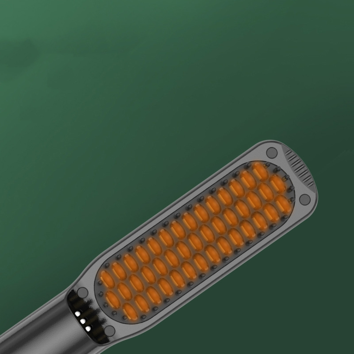 Black hair styling comb with orange heating elements on green background.