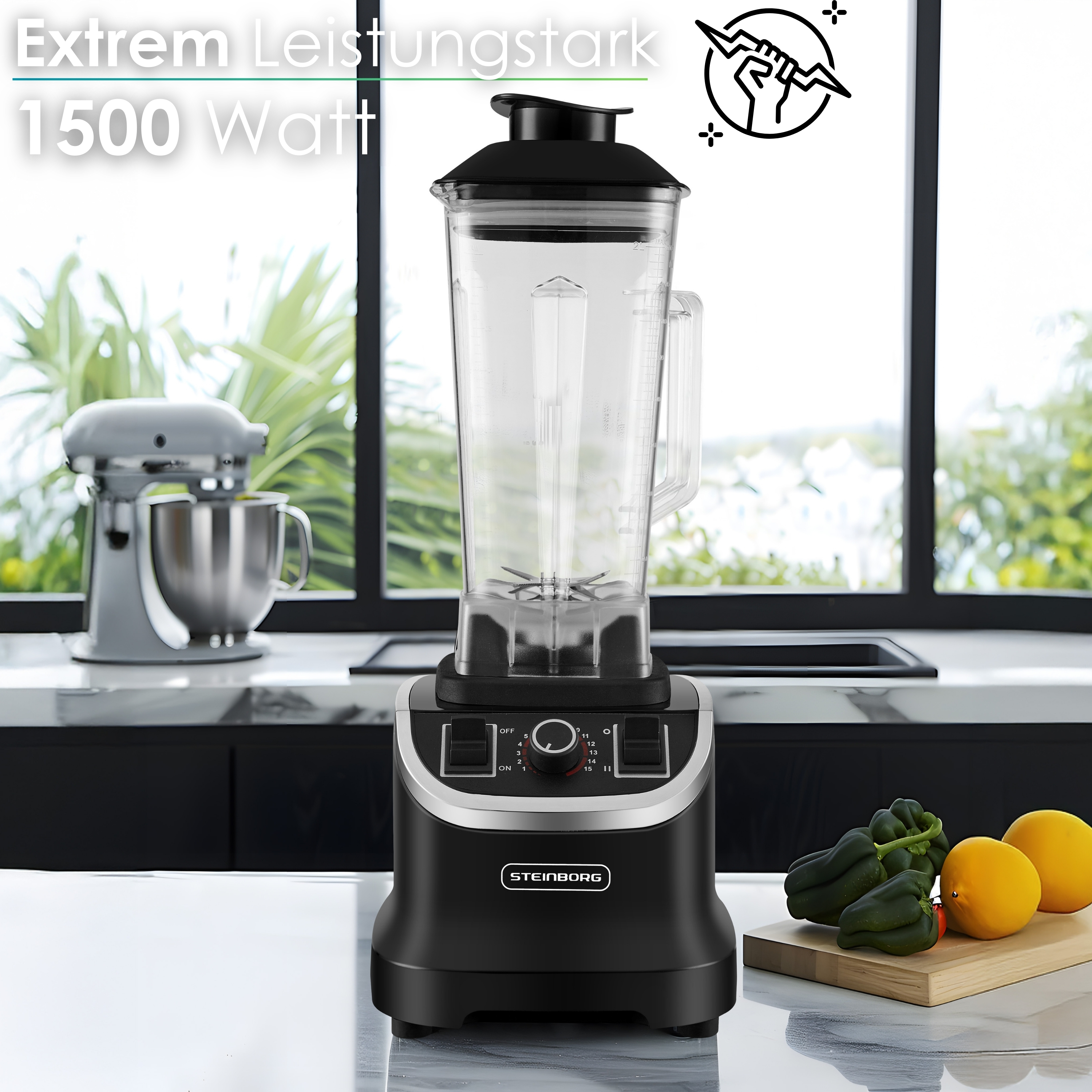 Schwarzer Mixer auf der Theke, Küchenszene. Mixer links. Drei grüne Paprika und zwei Orangen rechts.