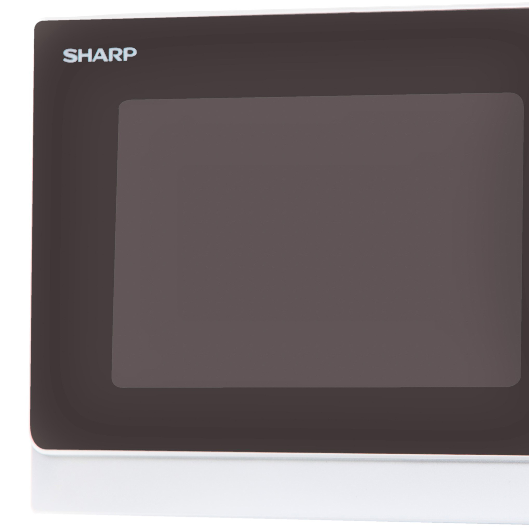 Zbliżenie kuchenki mikrofalowej. Drzwi są ciemne i prostokątne. Widoczna marka SHARP.